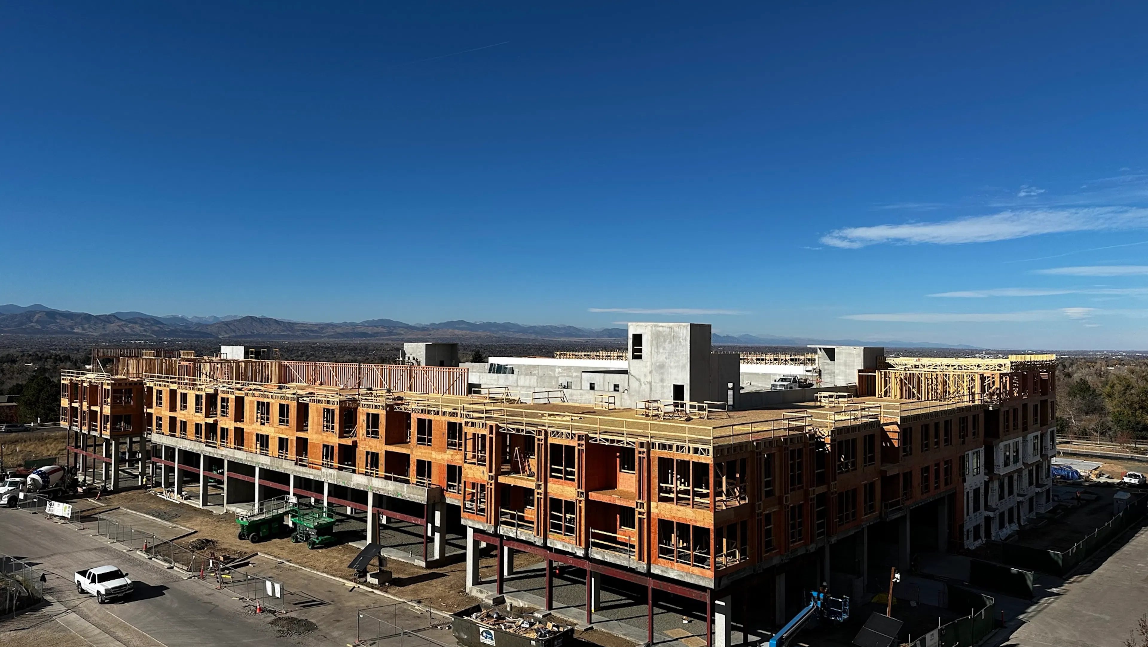 AMLI Village Park under construction set against a clear blue sky and distant mountains