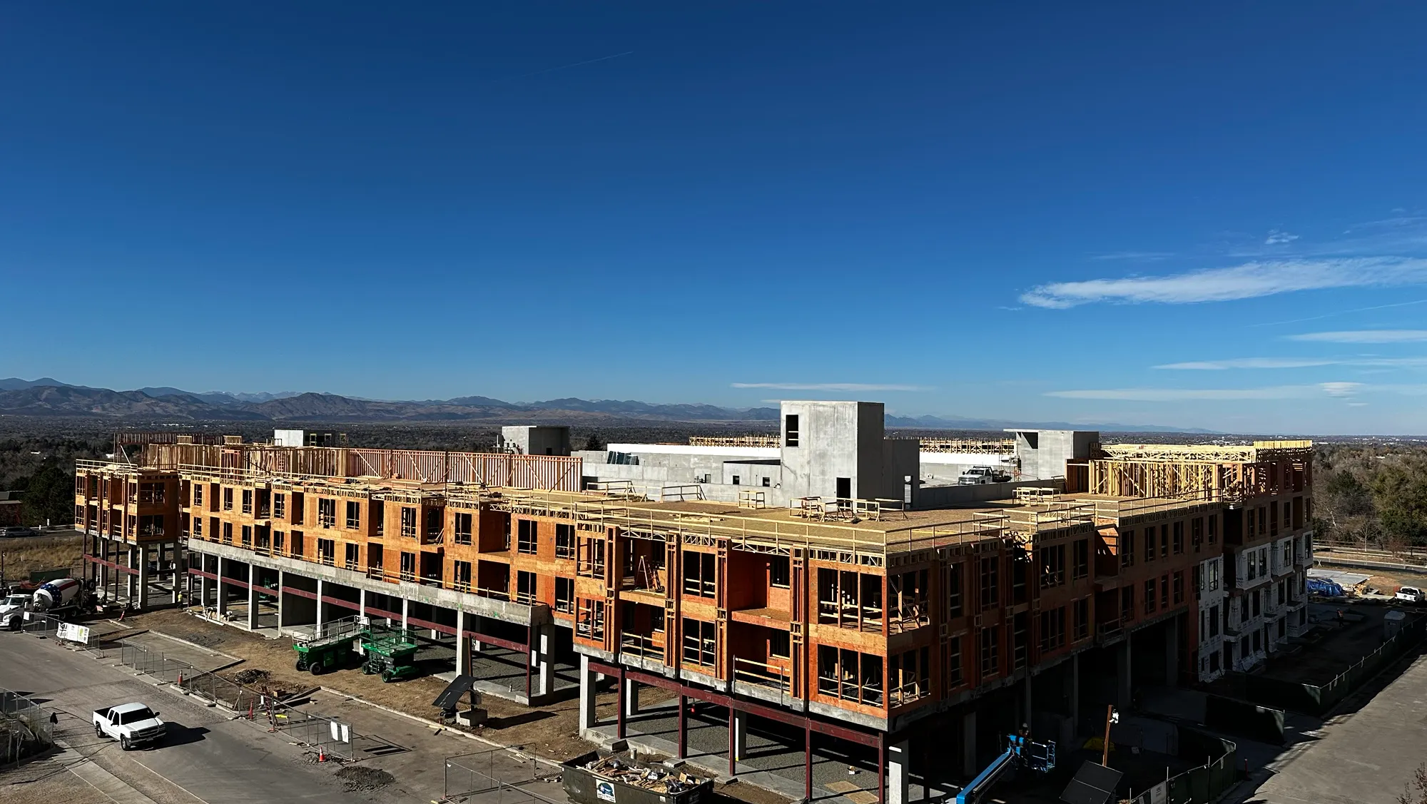 AMLI Village Park under construction set against a clear blue sky and distant mountains