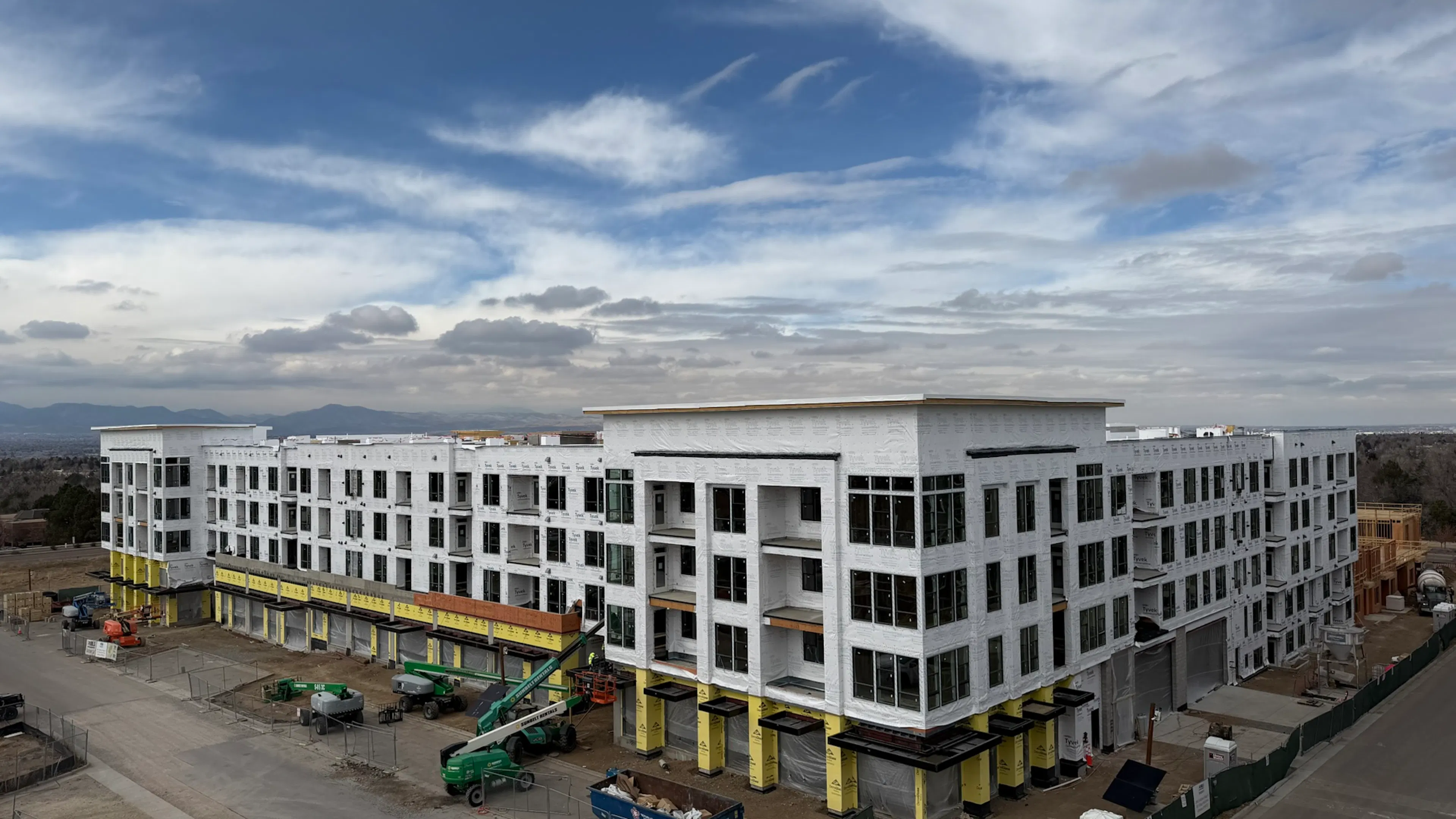 Construction progress view at AMLI Village Park with Building 1 framing topped out and roofing started