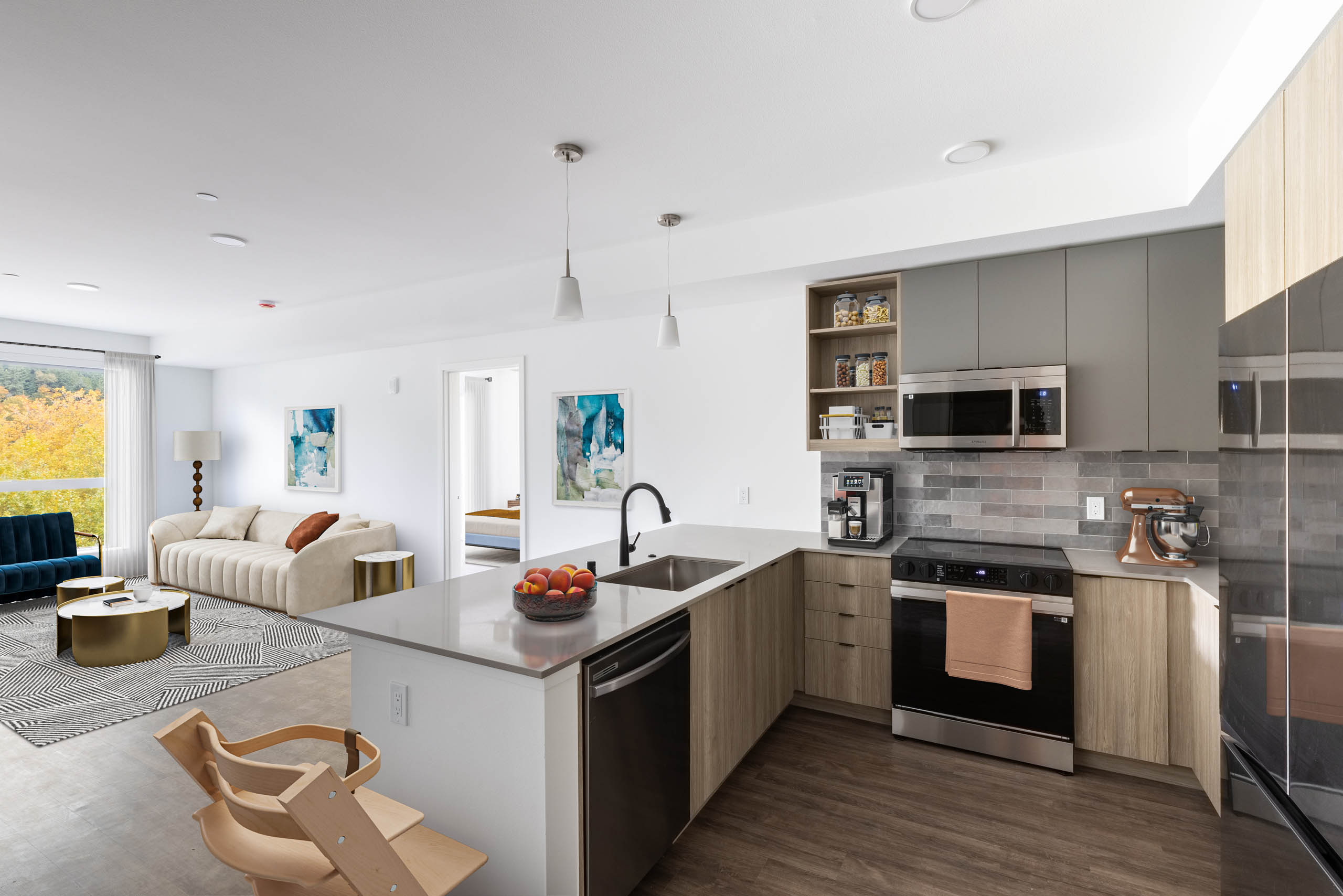 Interior view of AMLI Redmond Way apartment kitchen with gray tile backsplash, quartz counters, light wood cabinets and a child's high chair