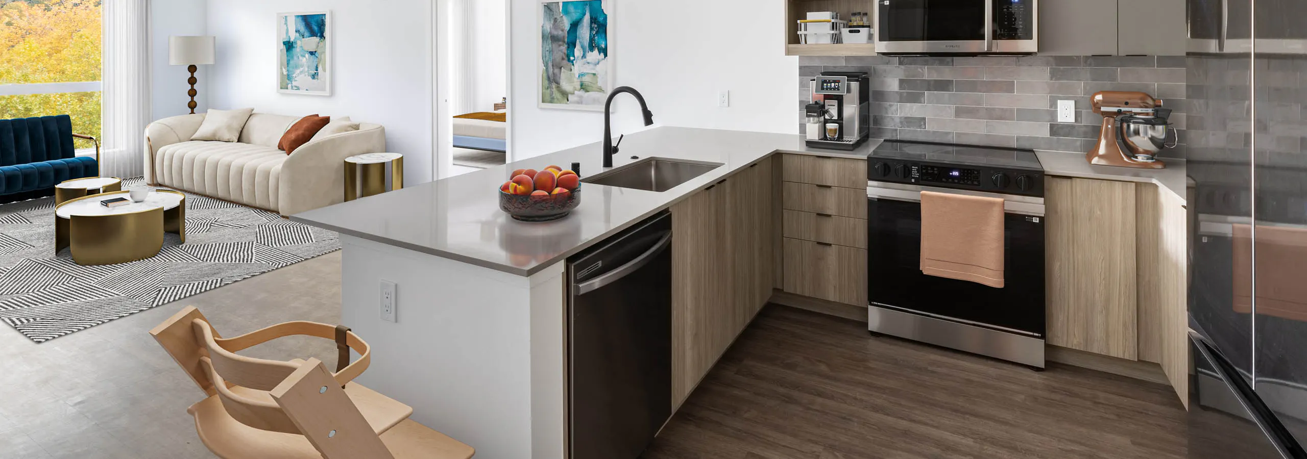 Interior view of AMLI Redmond Way apartment kitchen with gray tile backsplash, quartz counters, light wood cabinets and a child's high chair