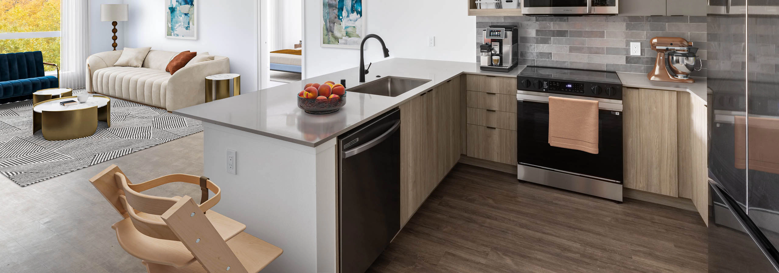 Interior view of AMLI Redmond Way apartment kitchen with gray tile backsplash, quartz counters, light wood cabinets and a child's high chair