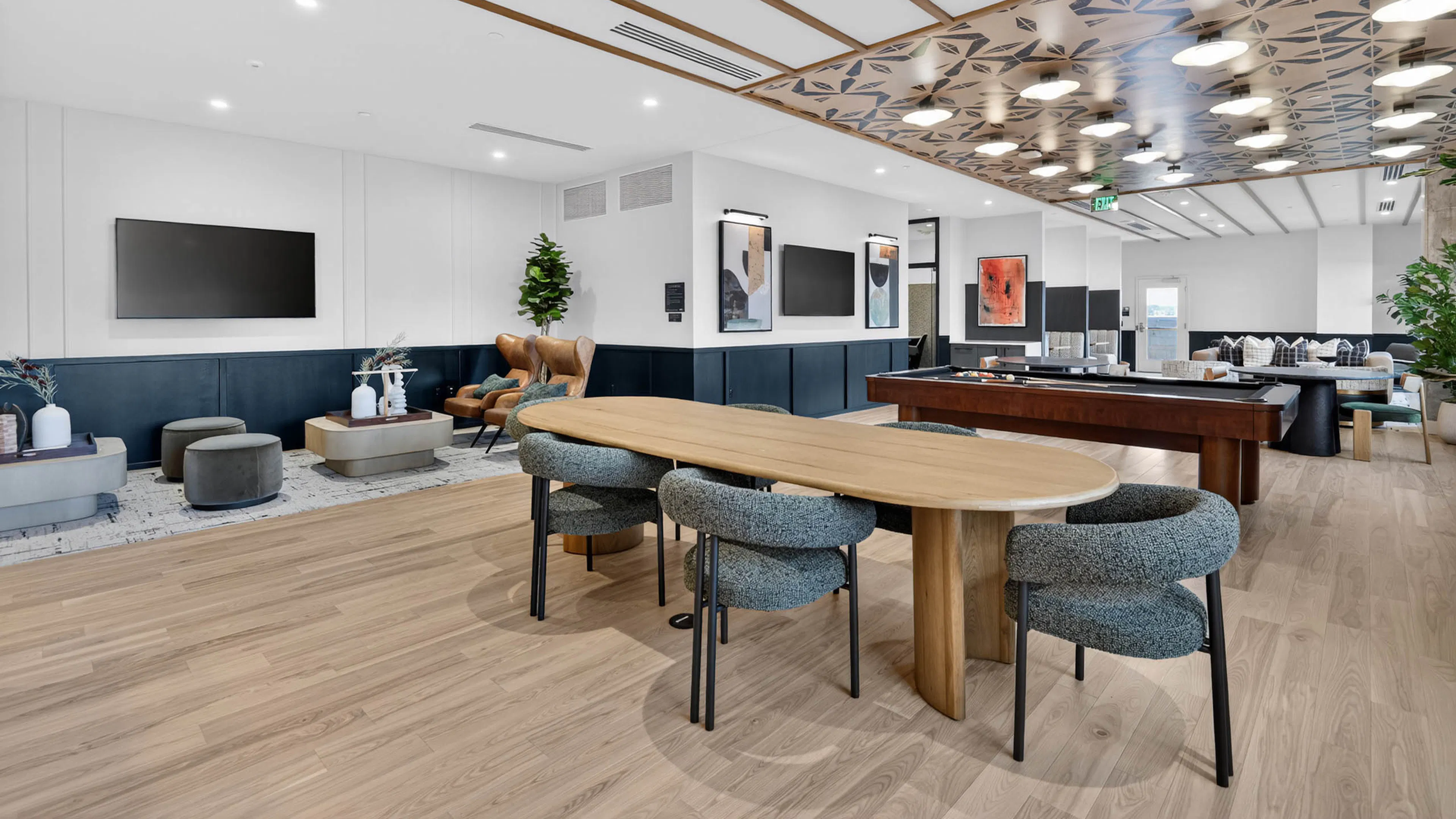 Community lounge at AMLI Golden Triangle apartments with built in booths sofa seating coffee tables and tall windows