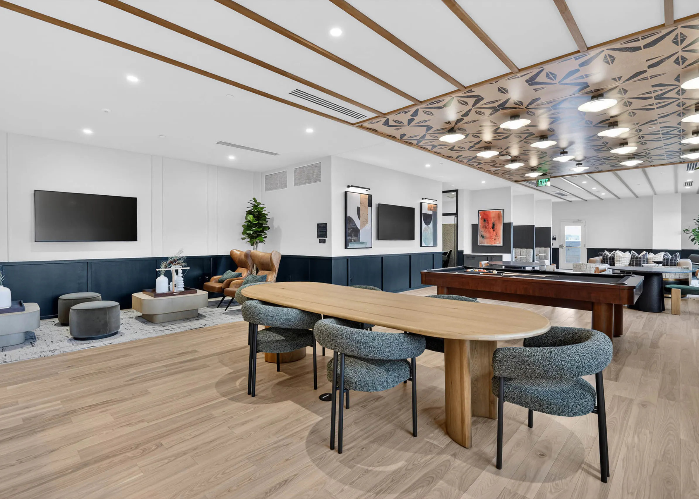 Community lounge at AMLI Golden Triangle apartments with built in booths sofa seating coffee tables and tall windows