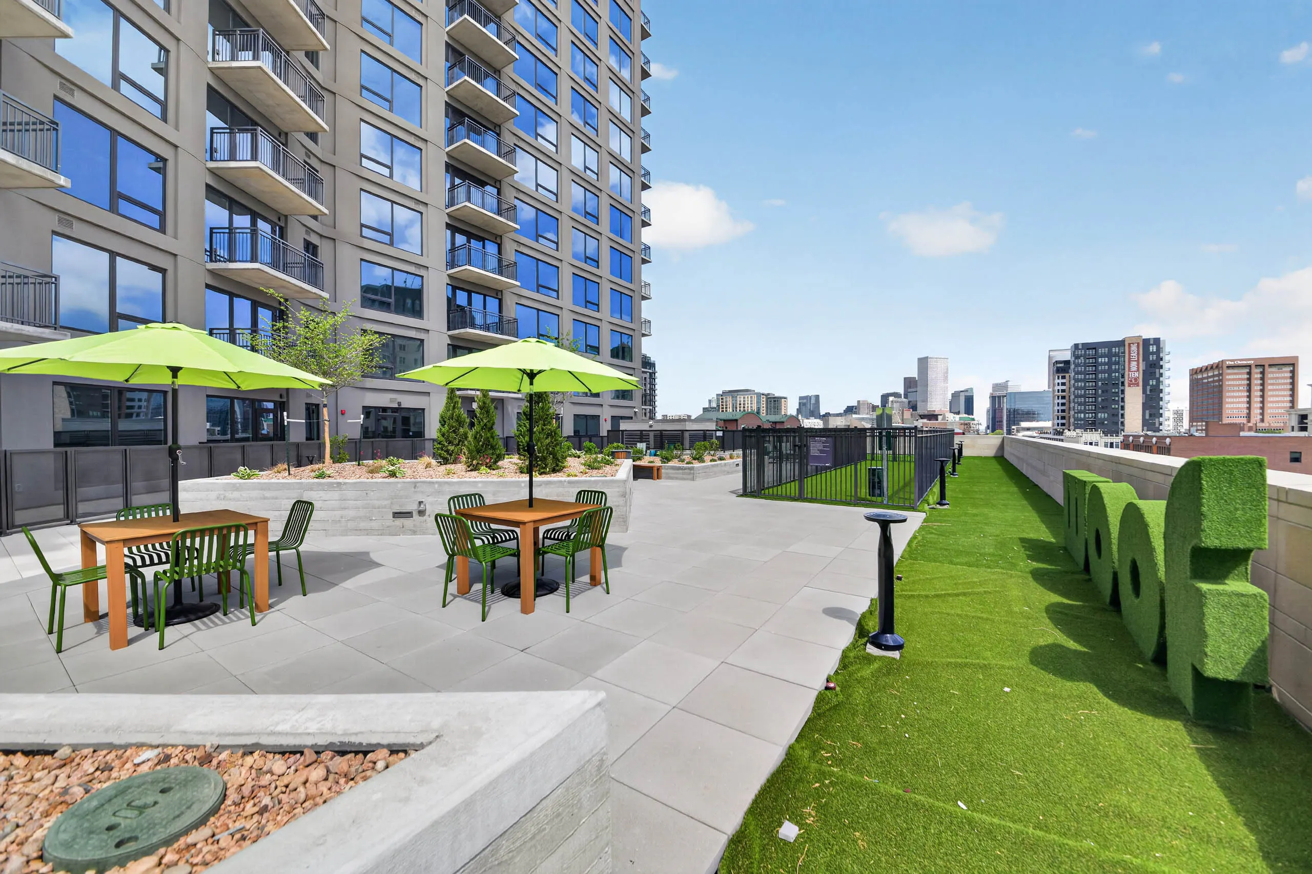 Courtyard lawn at AMLI Golden Triangle apartments with outdoor games lounge chairs fire pit and grilling pavilion