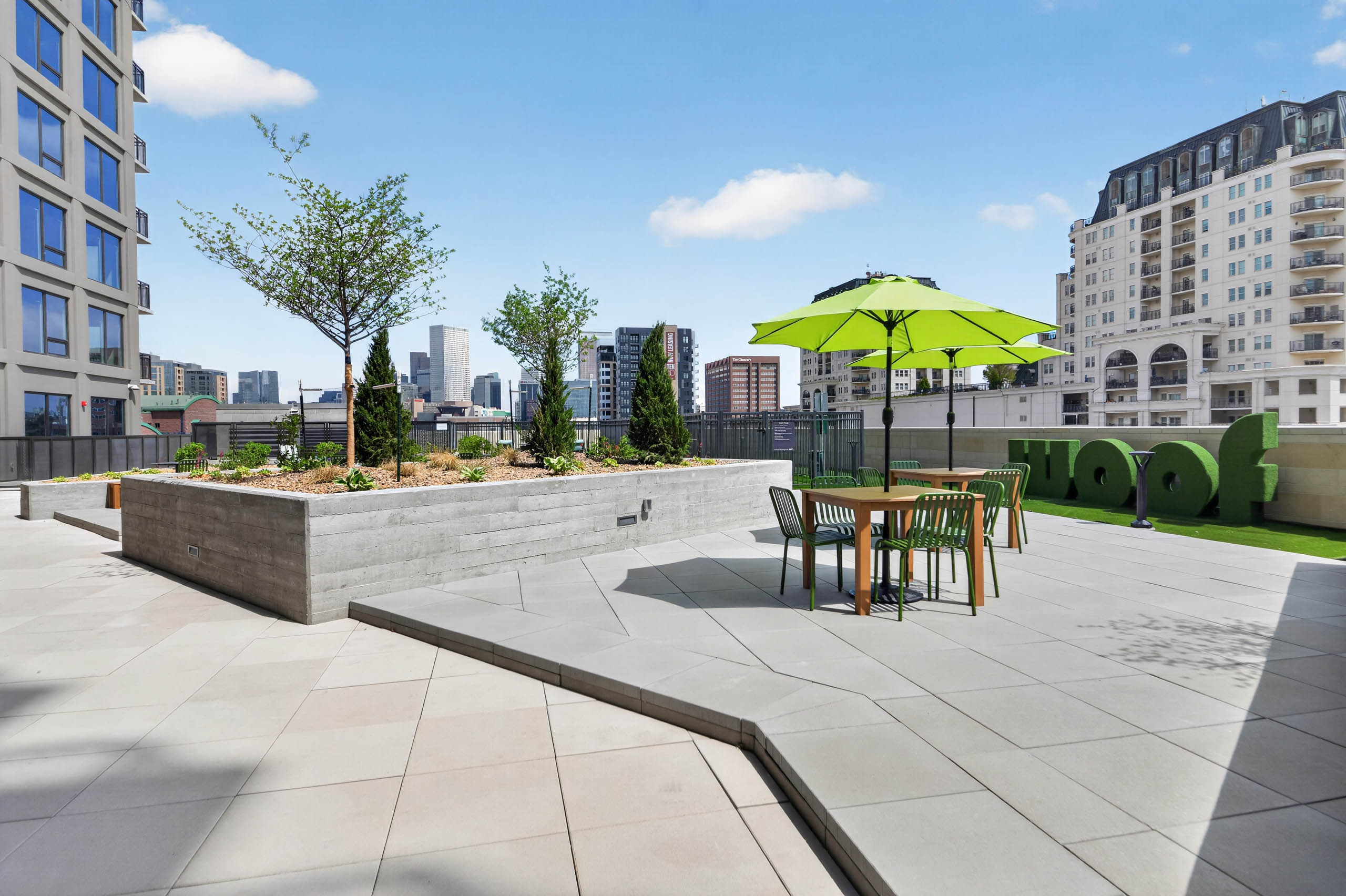 Courtyard lawn at AMLI Golden Triangle apartments with outdoor games lounge chairs fire pit and grilling pavilion