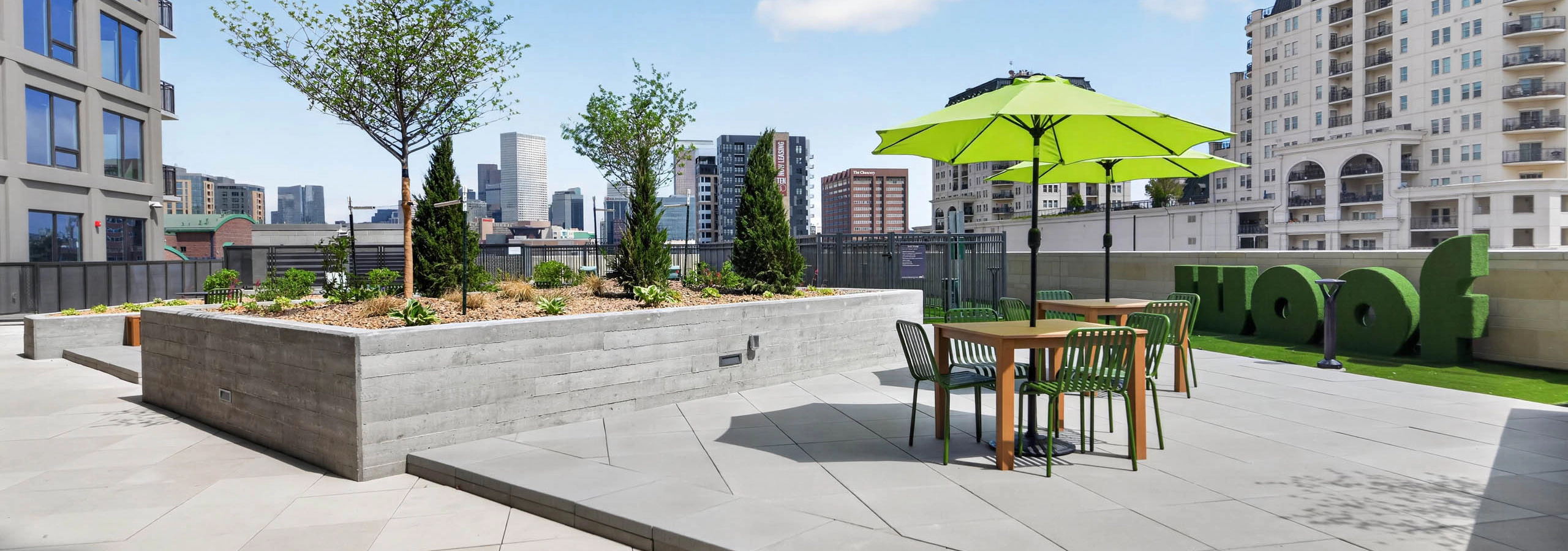 Courtyard lawn at AMLI Golden Triangle apartments with outdoor games lounge chairs fire pit and grilling pavilion