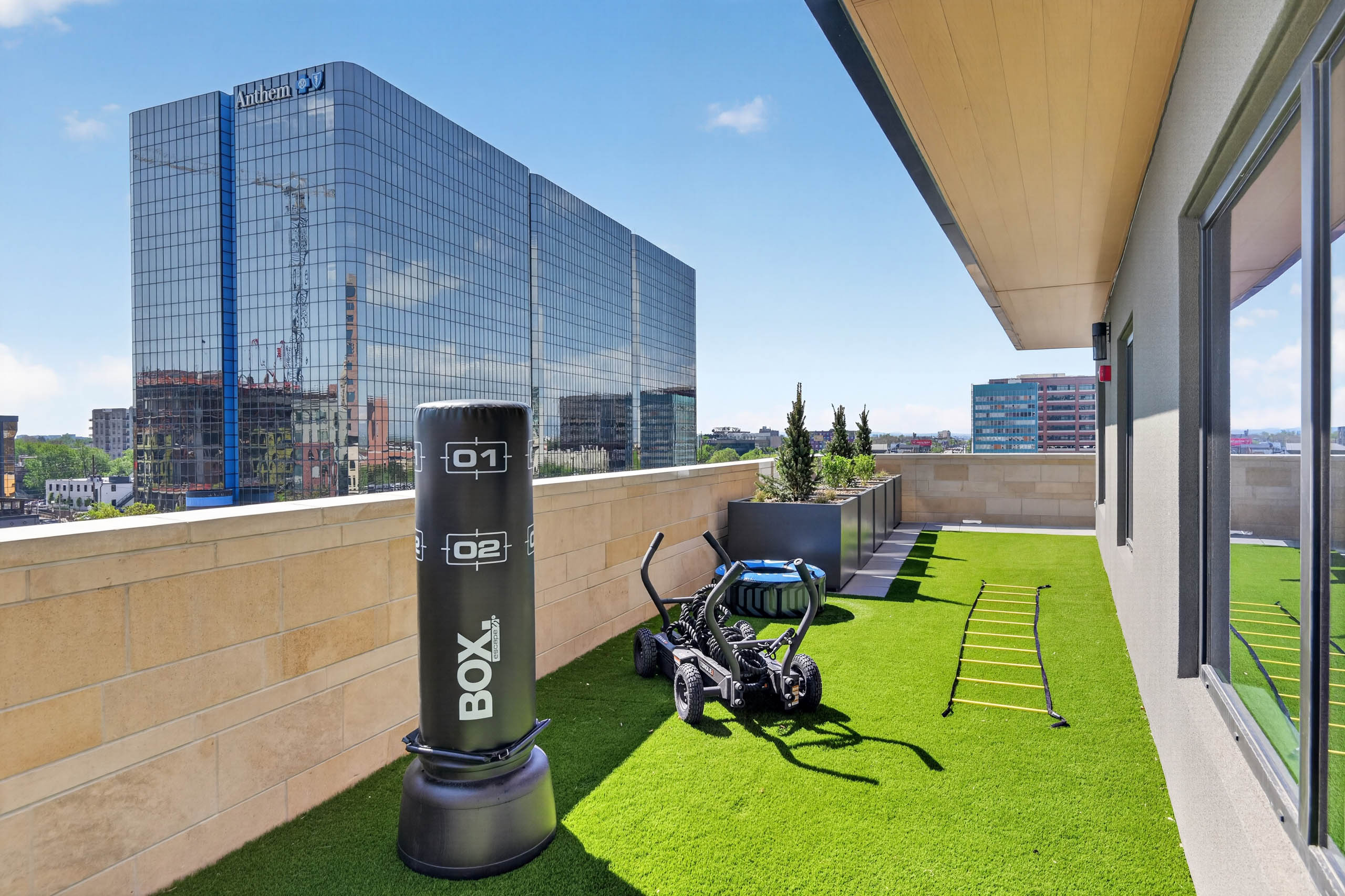 Outdoor fitness area at AMLI Golden Triangle apartments with turf surface punching bag training equipment and city views