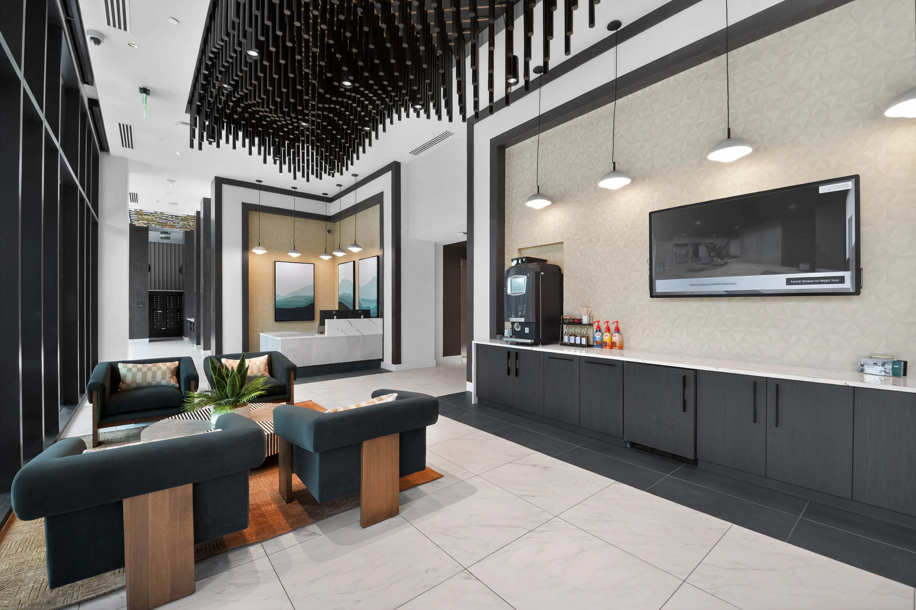 Lobby at AMLI Golden Triangle apartments with lounge seating coffee station modern lighting and concierge desk area