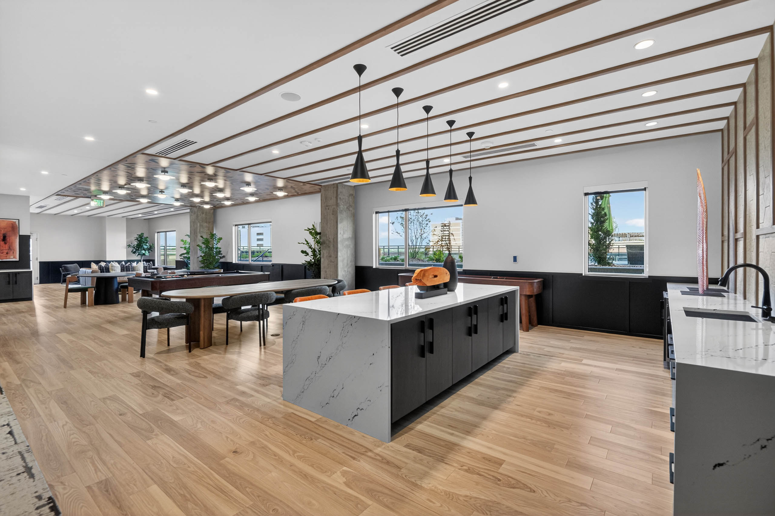 Resident lounge at AMLI Golden Triangle apartments with large island pendant lighting prep space and seating