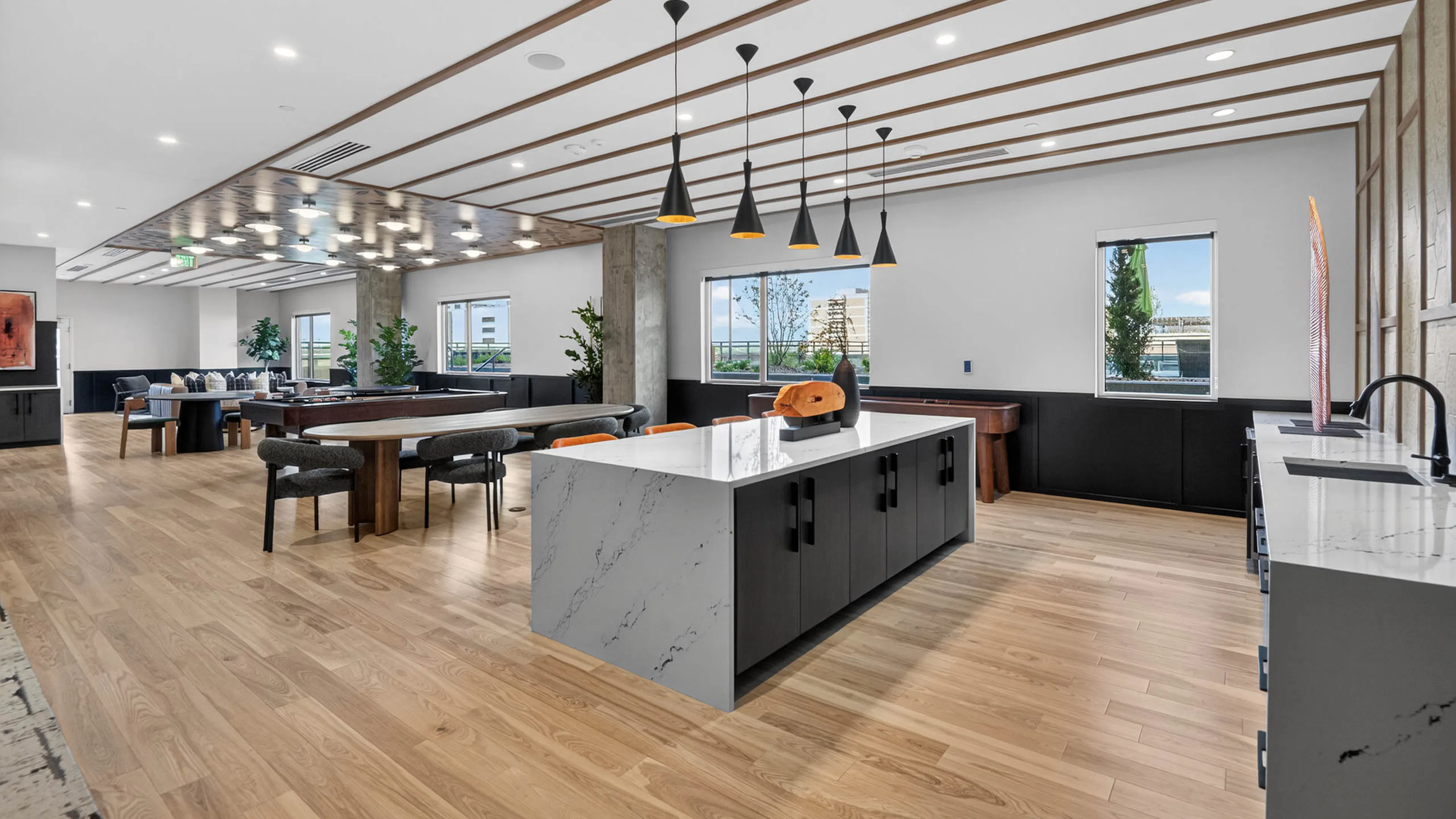 Resident lounge at AMLI Golden Triangle apartments with large island pendant lighting prep space and seating