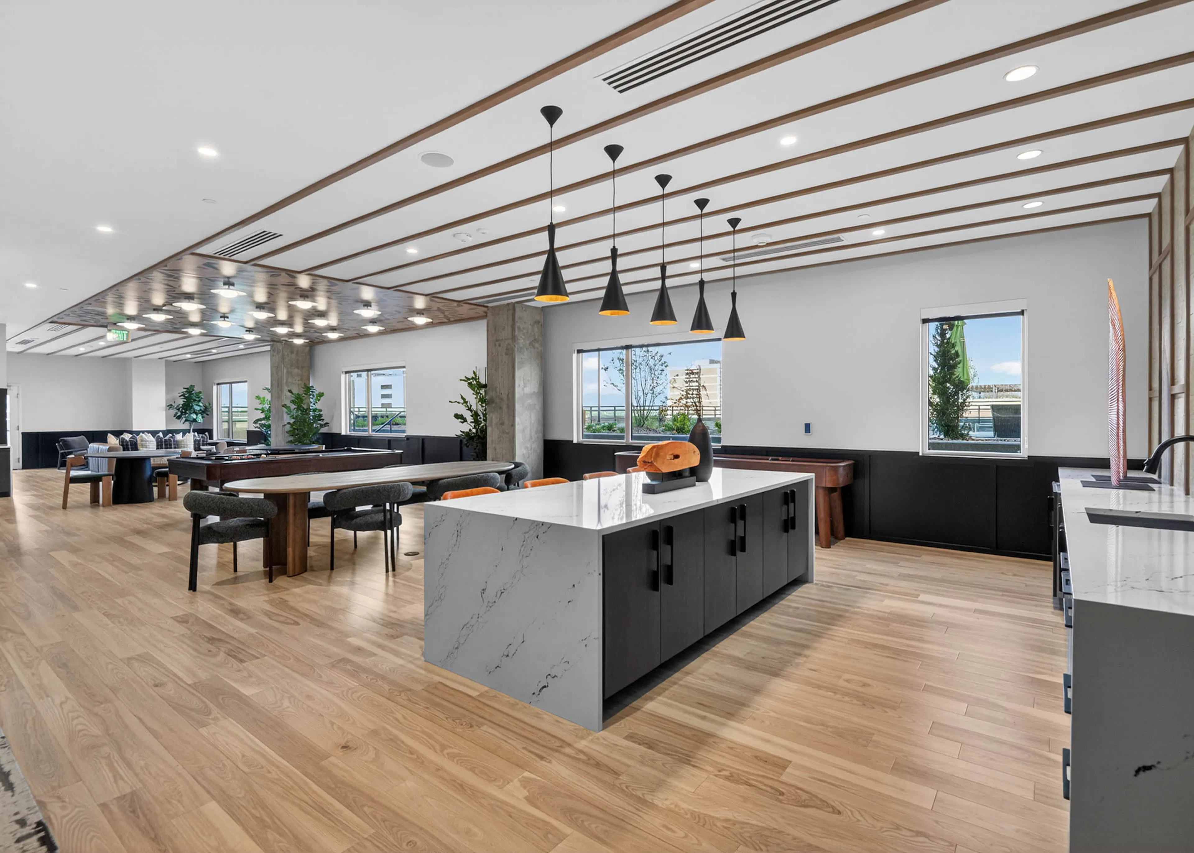 Resident lounge at AMLI Golden Triangle apartments with large island pendant lighting prep space and seating