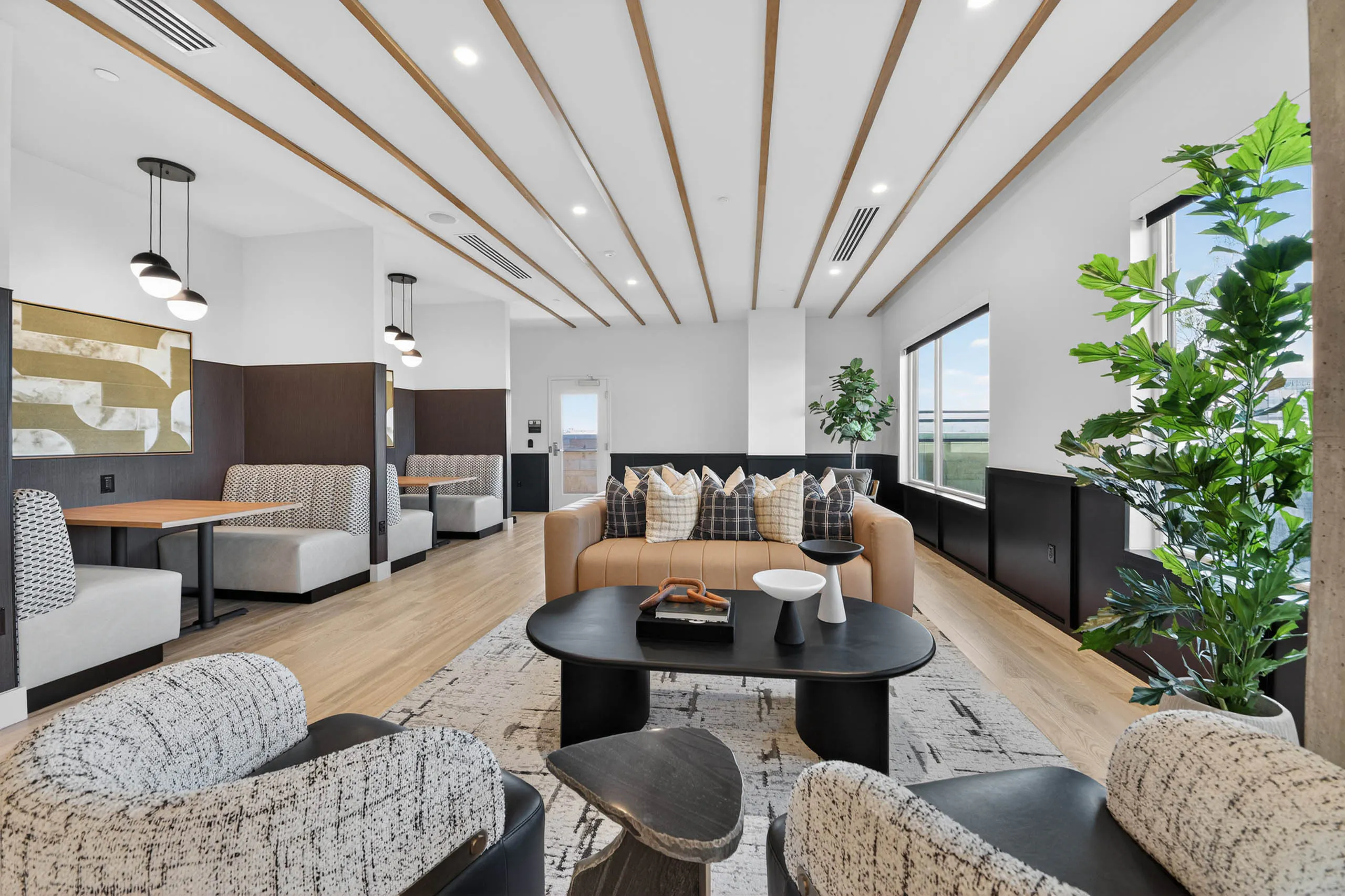 Resident lounge at AMLI Golden Triangle apartments with communal seating dining booth pool table and wood flooring