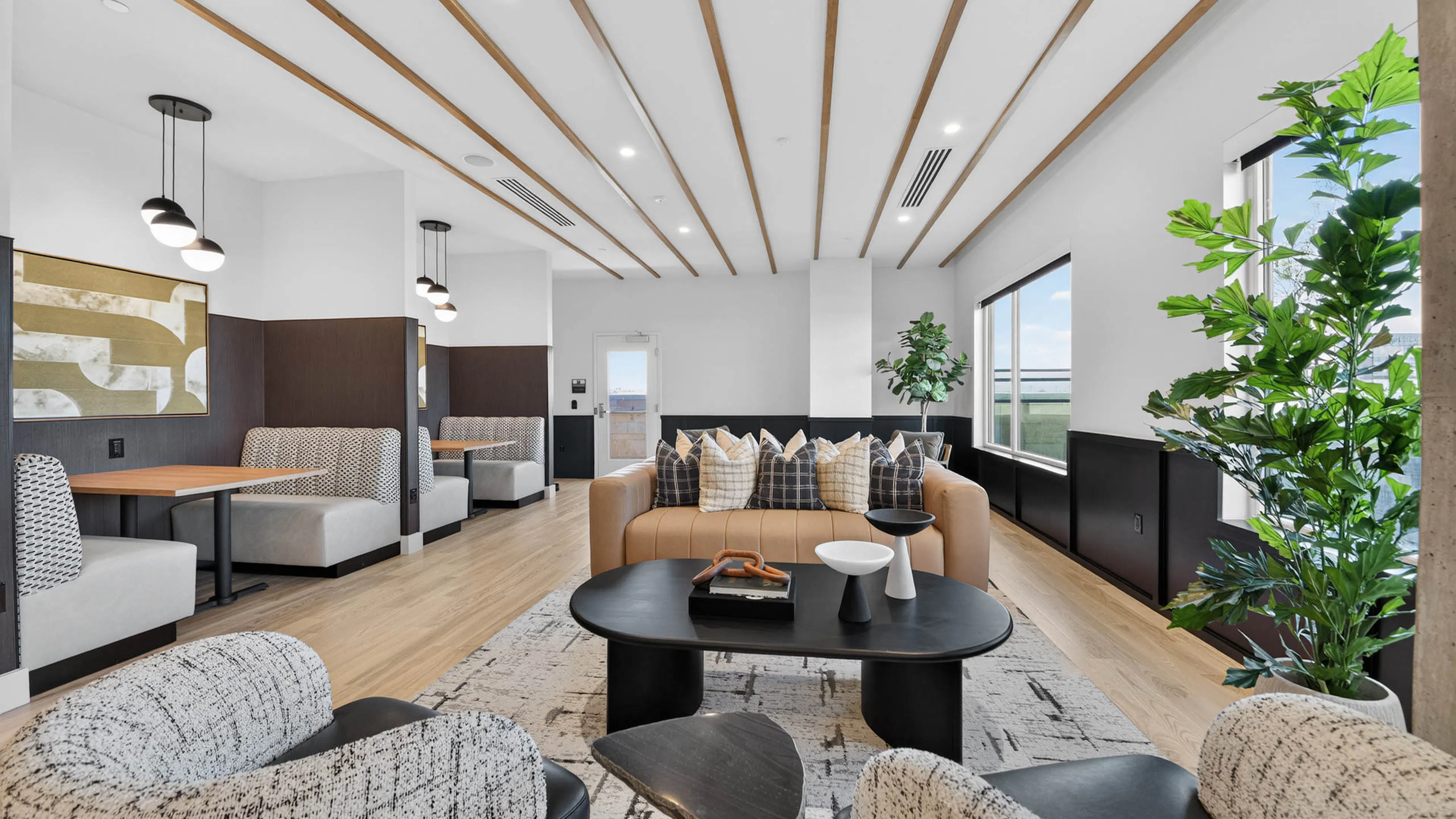 Resident lounge at AMLI Golden Triangle apartments with communal seating dining booth pool table and wood flooring