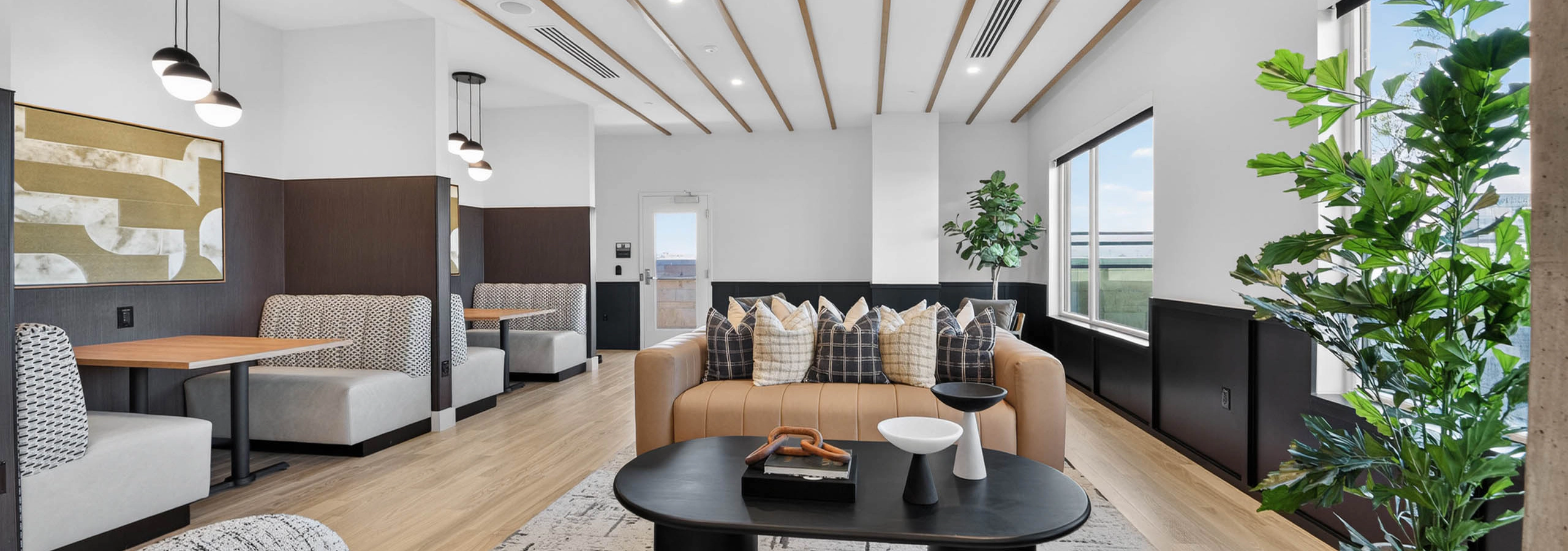 Resident lounge at AMLI Golden Triangle apartments with communal seating dining booth pool table and wood flooring