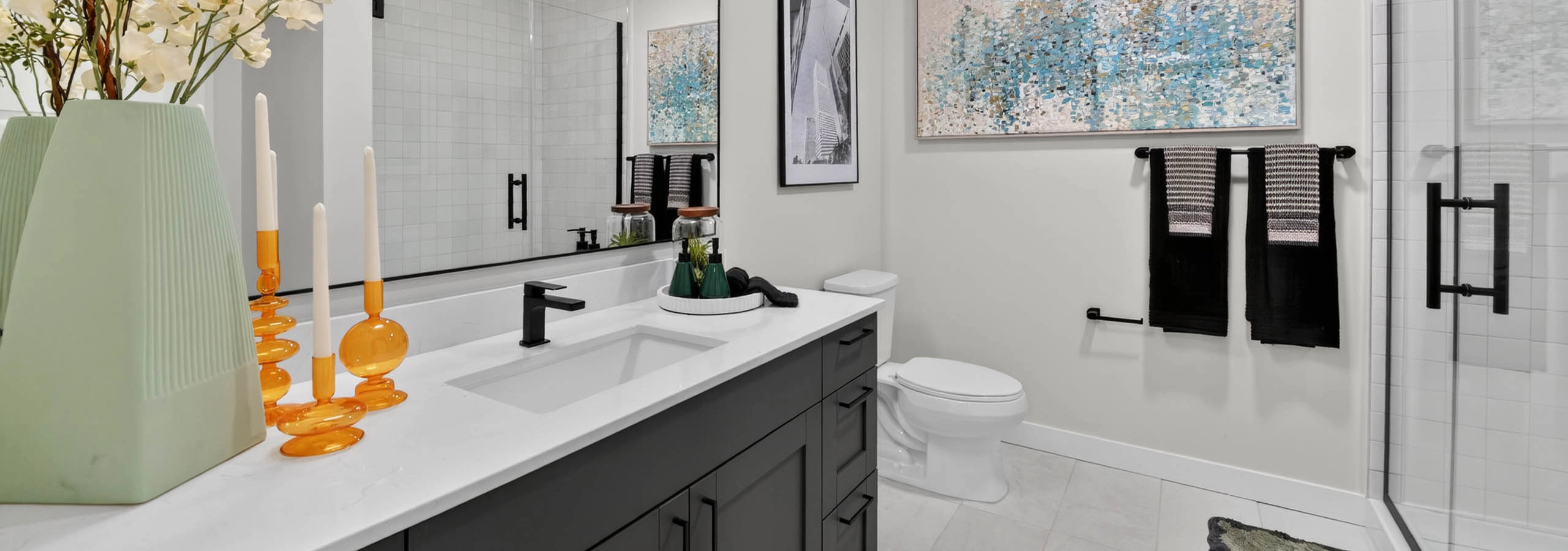 Bathroom at AMLI Golden Triangle apartment with double sink vanity large mirror glass shower and modern finishes