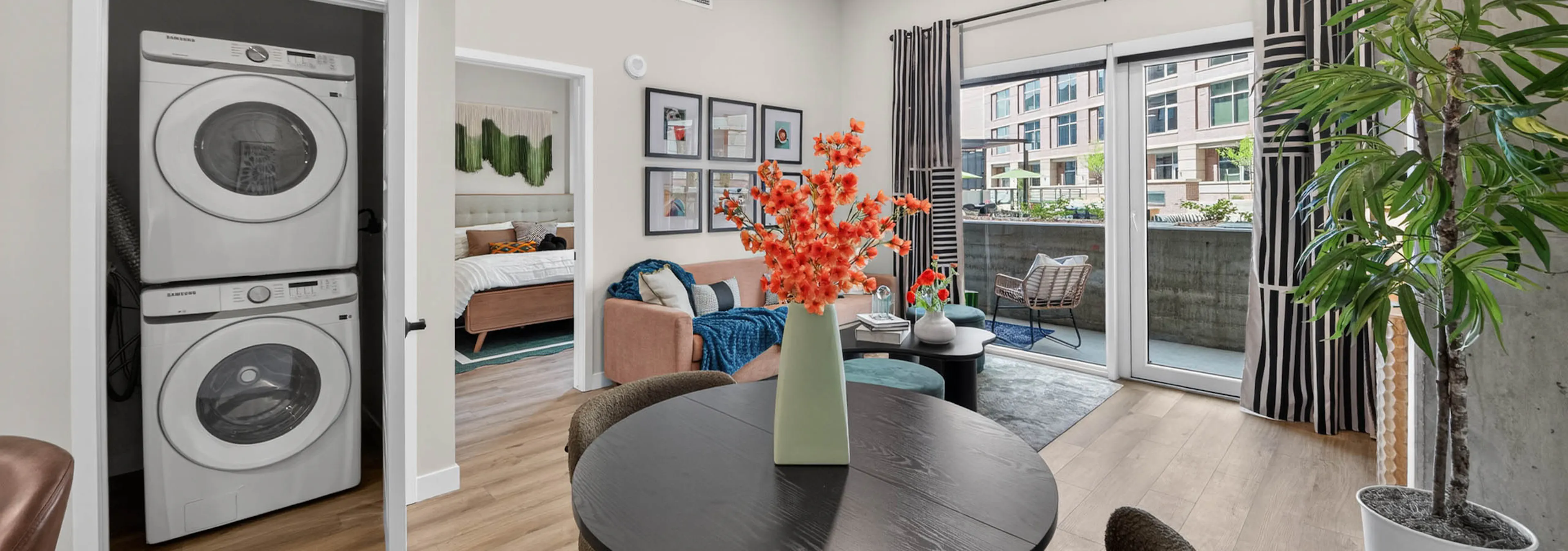 Dining area at AMLI Golden Triangle apartment with round table living room seating patio doors and in unit laundry closet