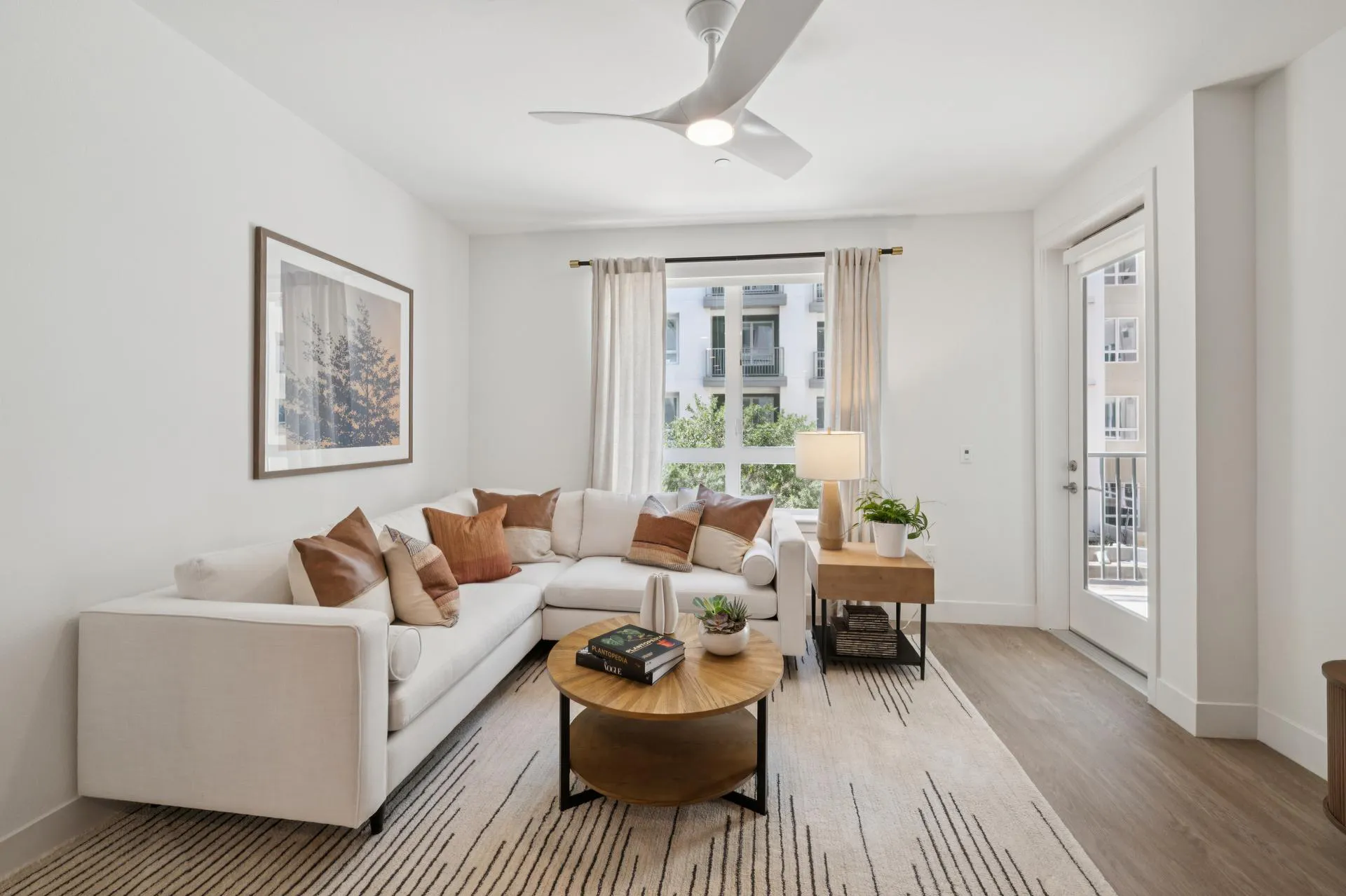 A naturally-lit living room with large windows and a white sofa 