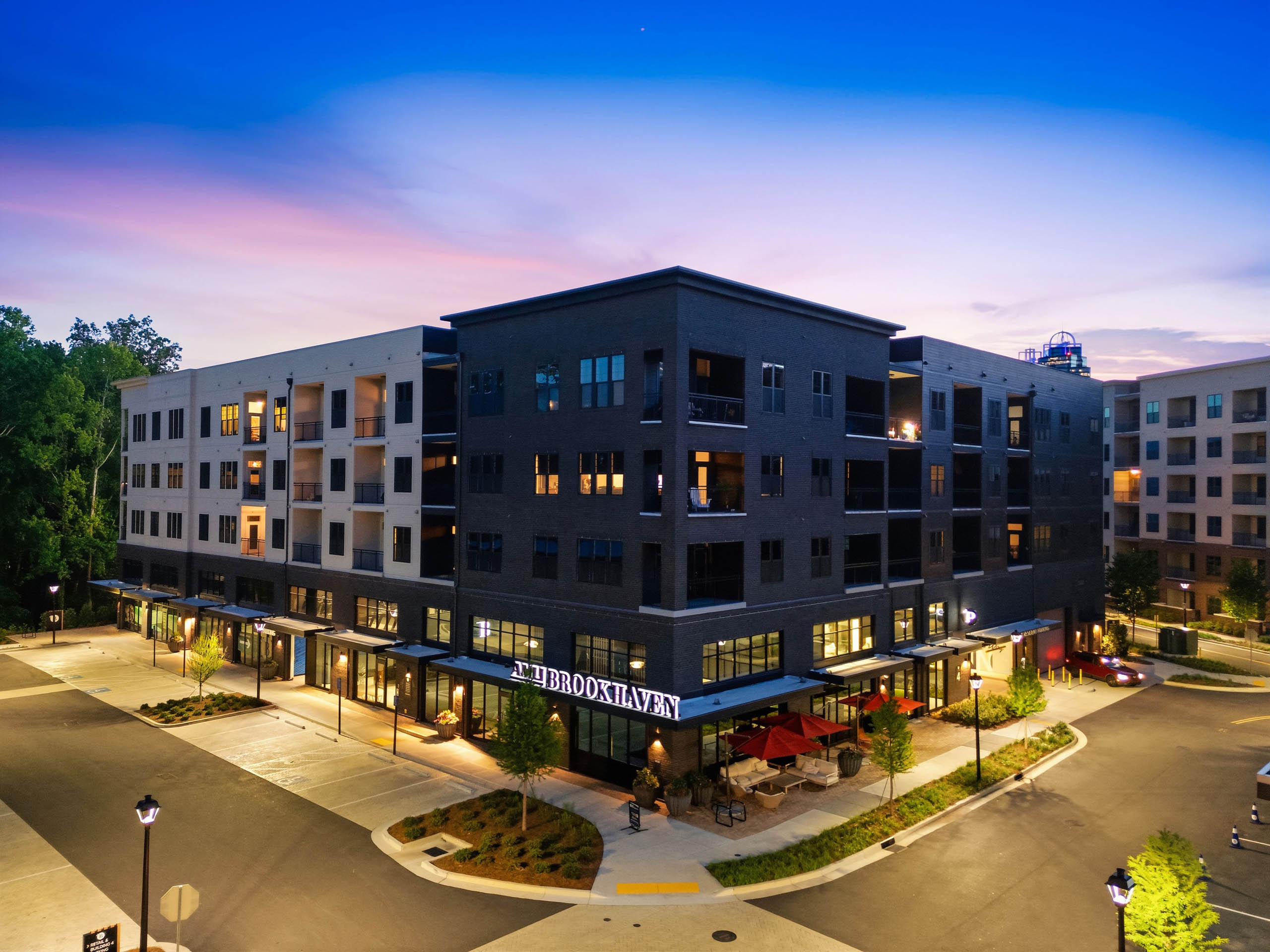Exterior View of AMLI Brookhaven at dusk featuring on-site parking and evening lighting.