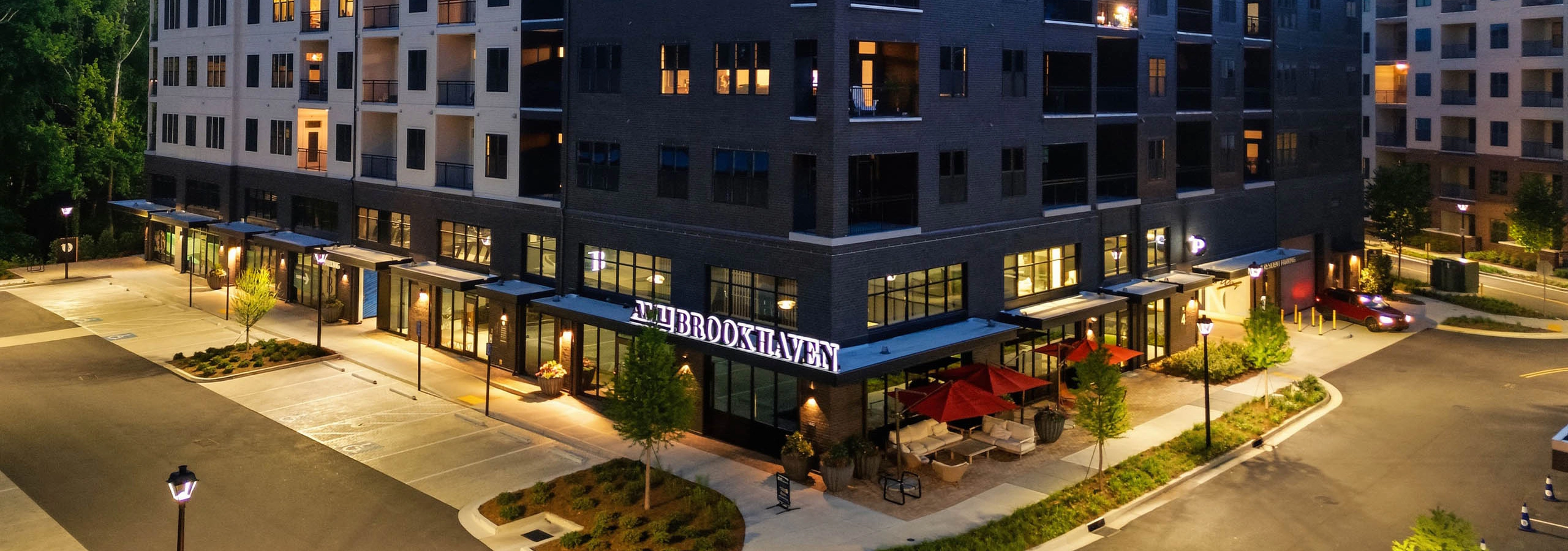Exterior View of AMLI Brookhaven at dusk featuring on-site parking and evening lighting.