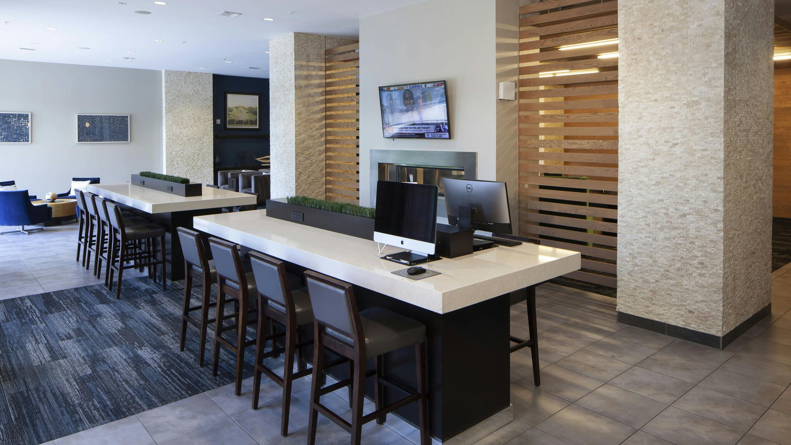Daytime view of the business center at AMLI Cherry Creek apartments with computers and work desks as well as wall art pieces