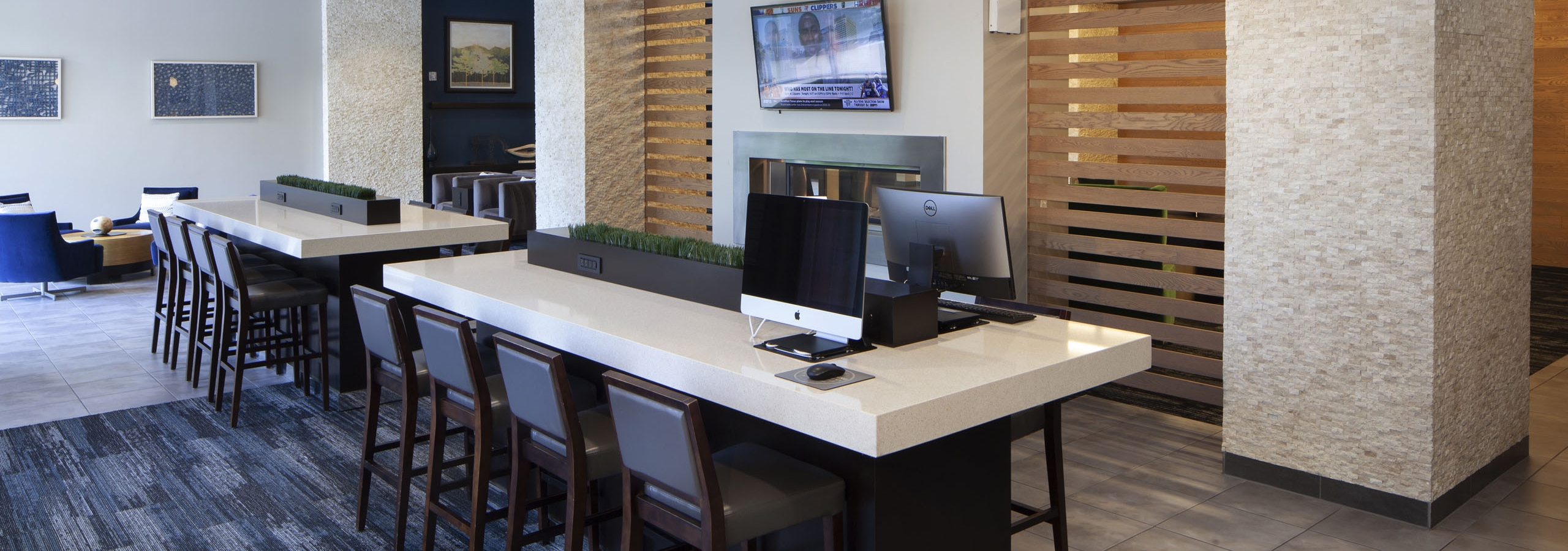 Daytime view of the business center at AMLI Cherry Creek apartments with computers and work desks as well as wall art pieces