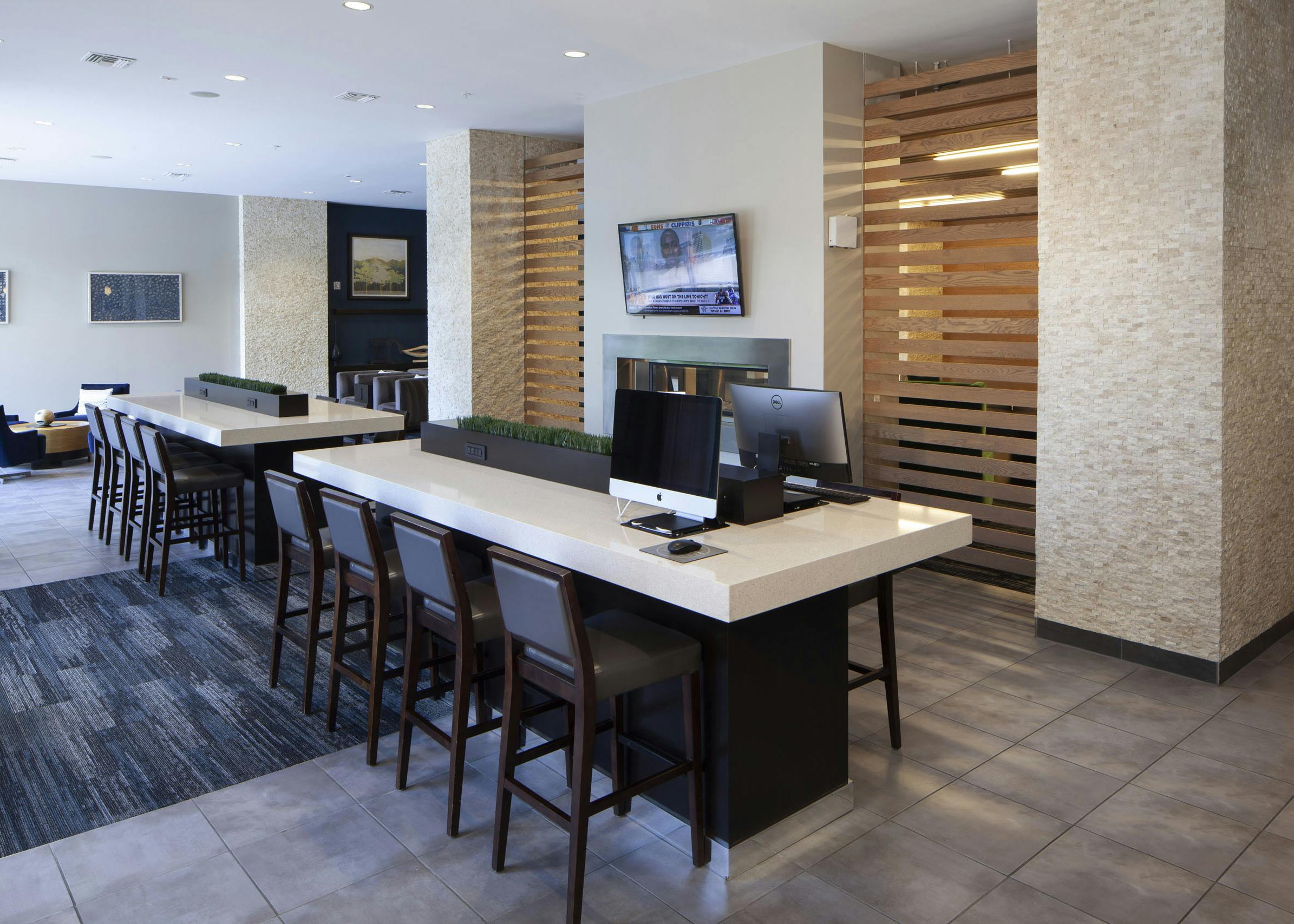 Daytime view of the business center at AMLI Cherry Creek apartments with computers and work desks as well as wall art pieces