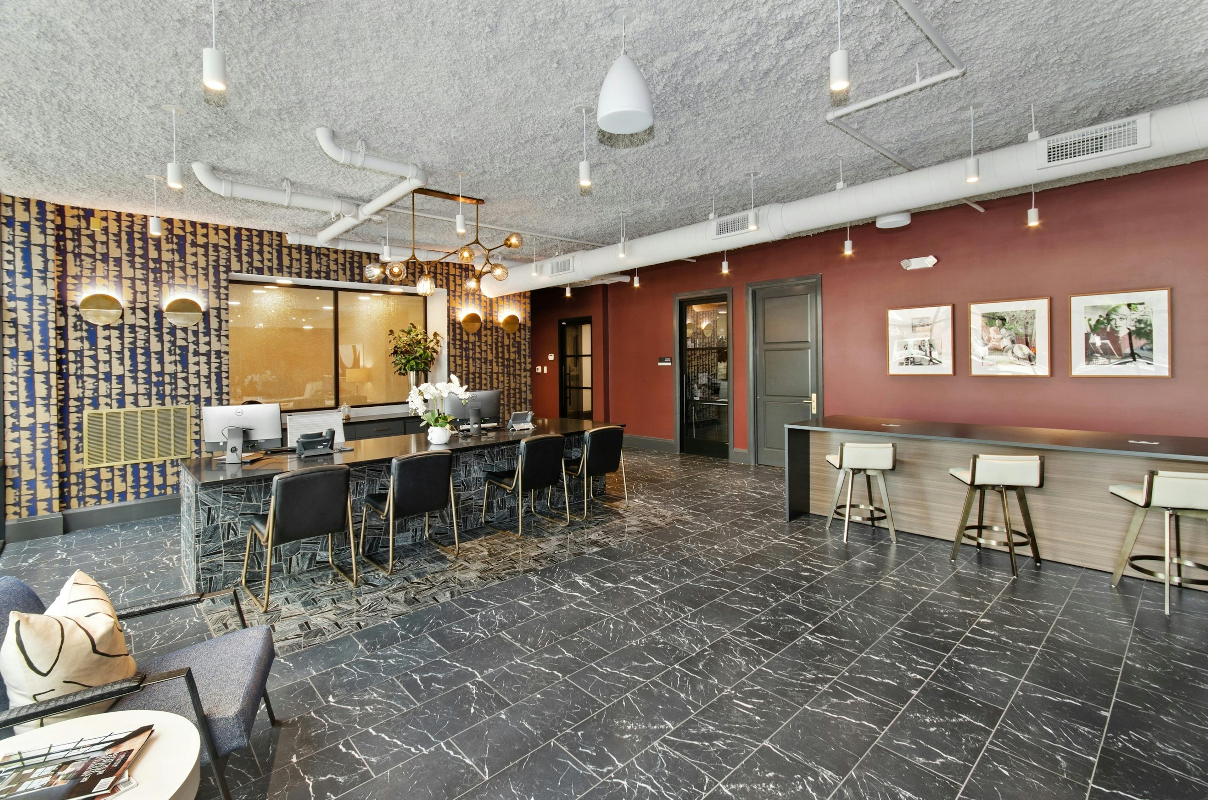 AMLI Quadrangle apartments leasing office with ample varied seating and two computer stations on a black and gray desk