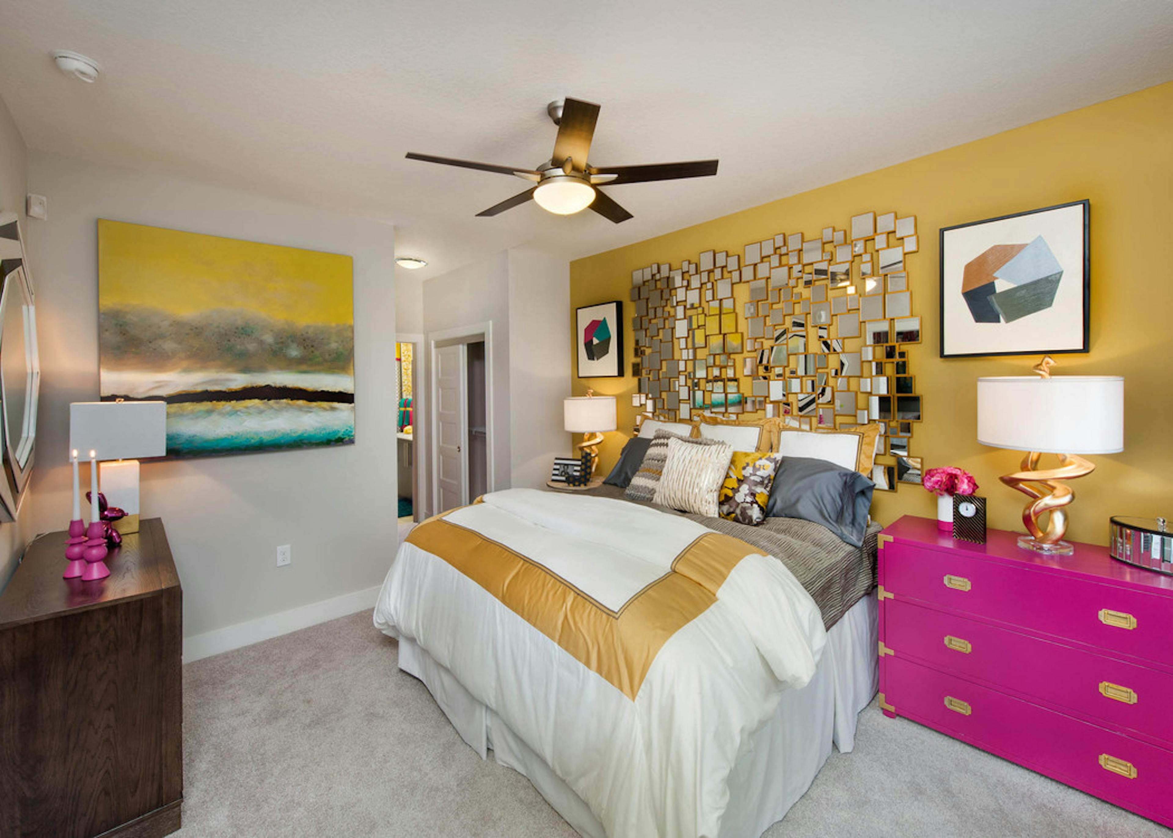 Interior of an AMLI Piedmont Heights bedroom with a gold wall while the others are grey with carpet and bright colorful decor