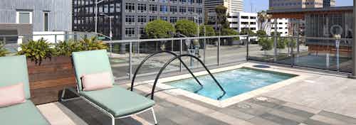 AMLI Park Broadway apartment building elevated heated spa and lounge chairs overlooking the Long Beach Downtown buildings