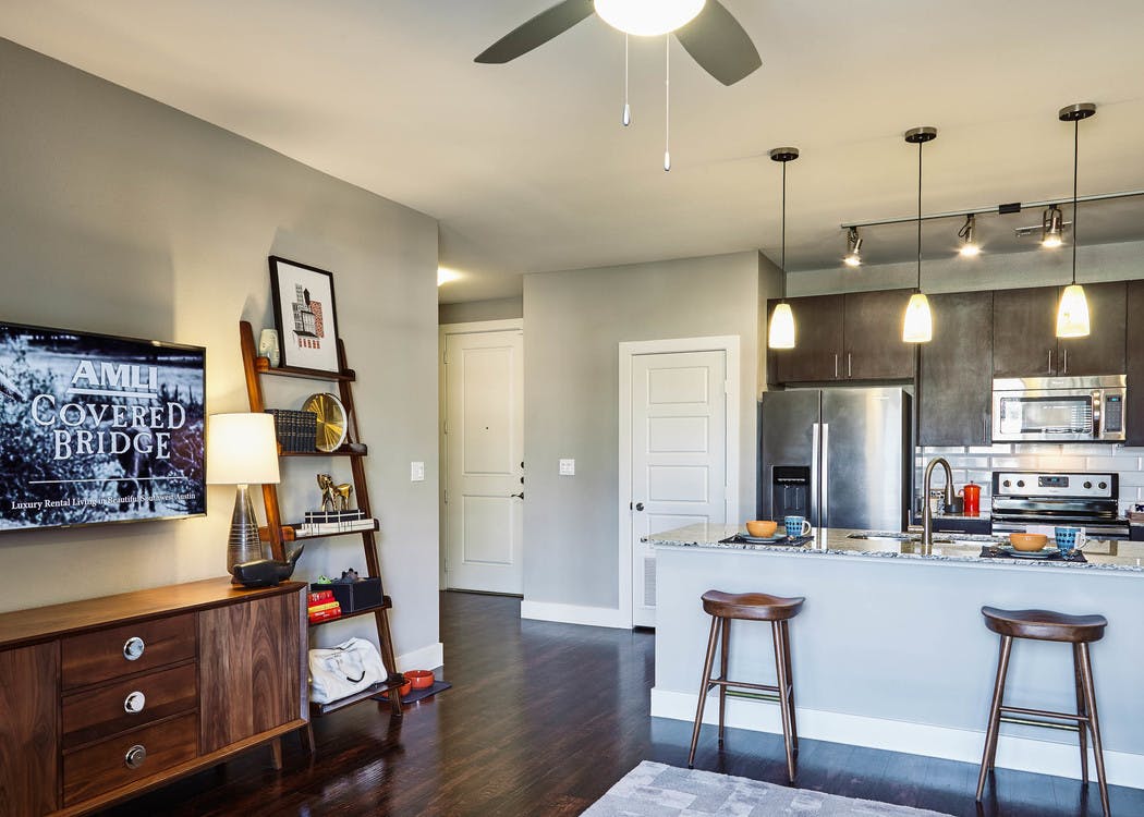 AMLI Covered Bridge model kitchen with 42" espresso cabinets with brushed chrome hardware and pendant lights