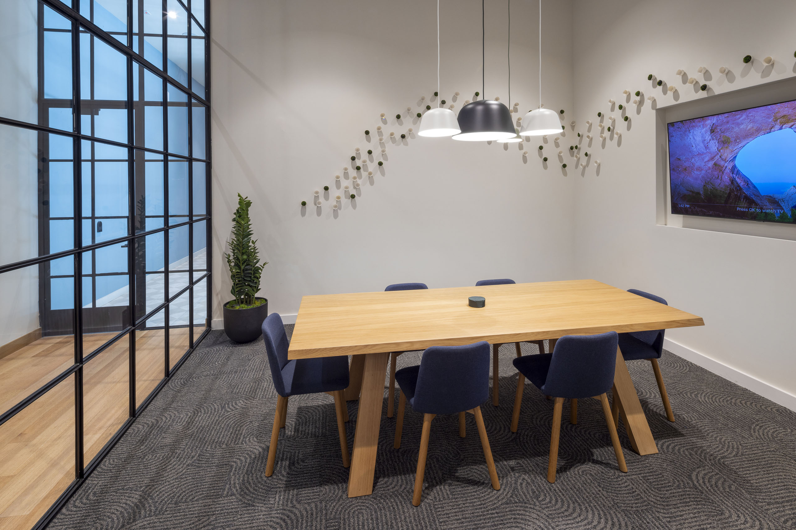 A rentable business conference room at AMLI Branch Park apartments with a large wooden table and six cushion chairs