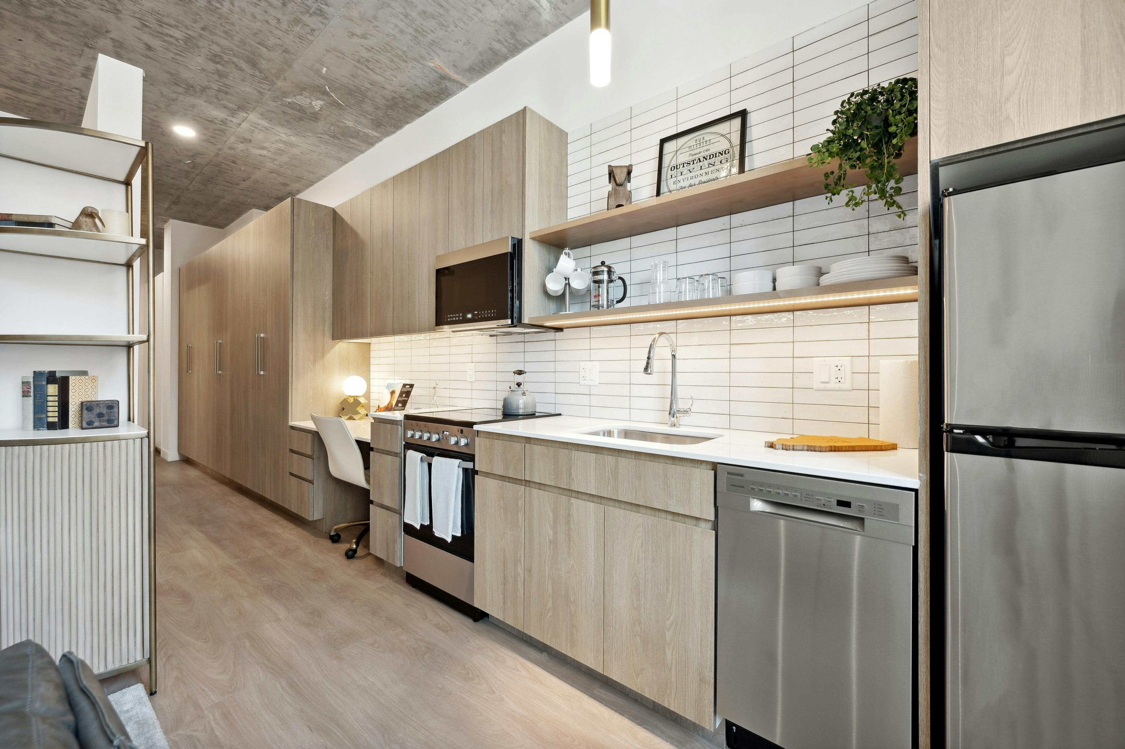 Kitchen with light wood cabinets and white tile backsplash and open shelving with distressed ceiling at AMLI 808 apartments