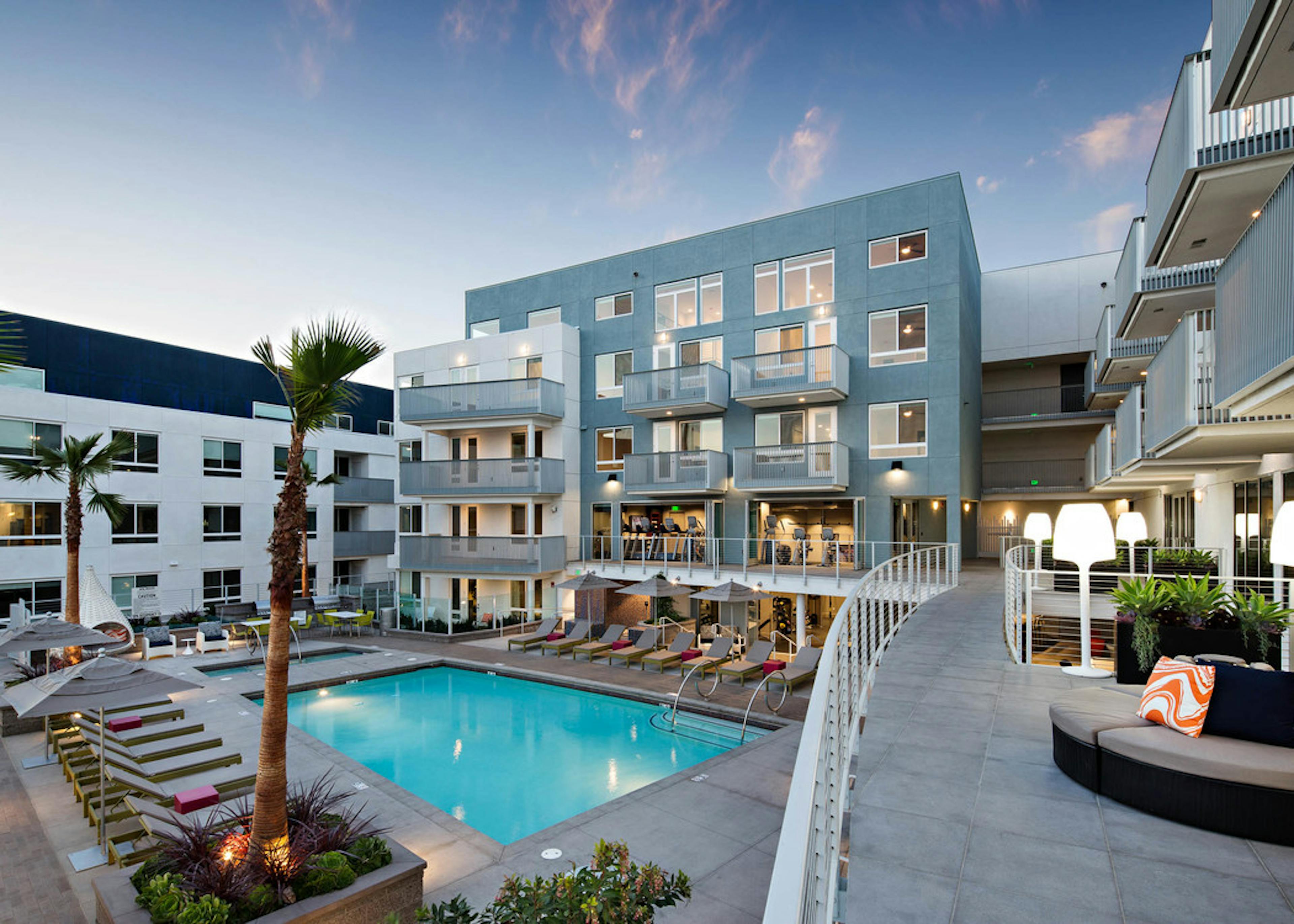 Daytime aerial view of AMLI Lex on Orange swimming pool area with lounge seating and umbrellas overlooking the fitness center