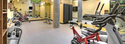 Interior of the fitness center at AMLI South Lake Union with treadmills cycle bikes free weights and fitness on demand