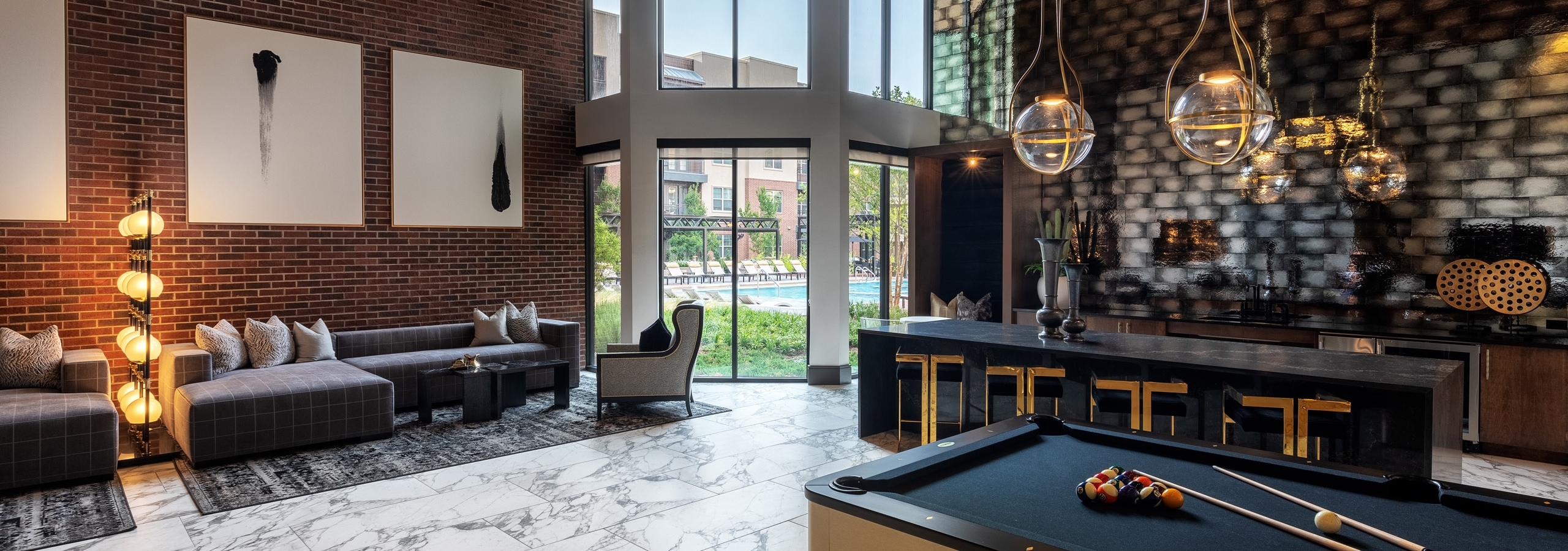 AMLI Grapevine apartment building clubroom with gray tile flooring and catering kitchen and lounge seating and pool table
