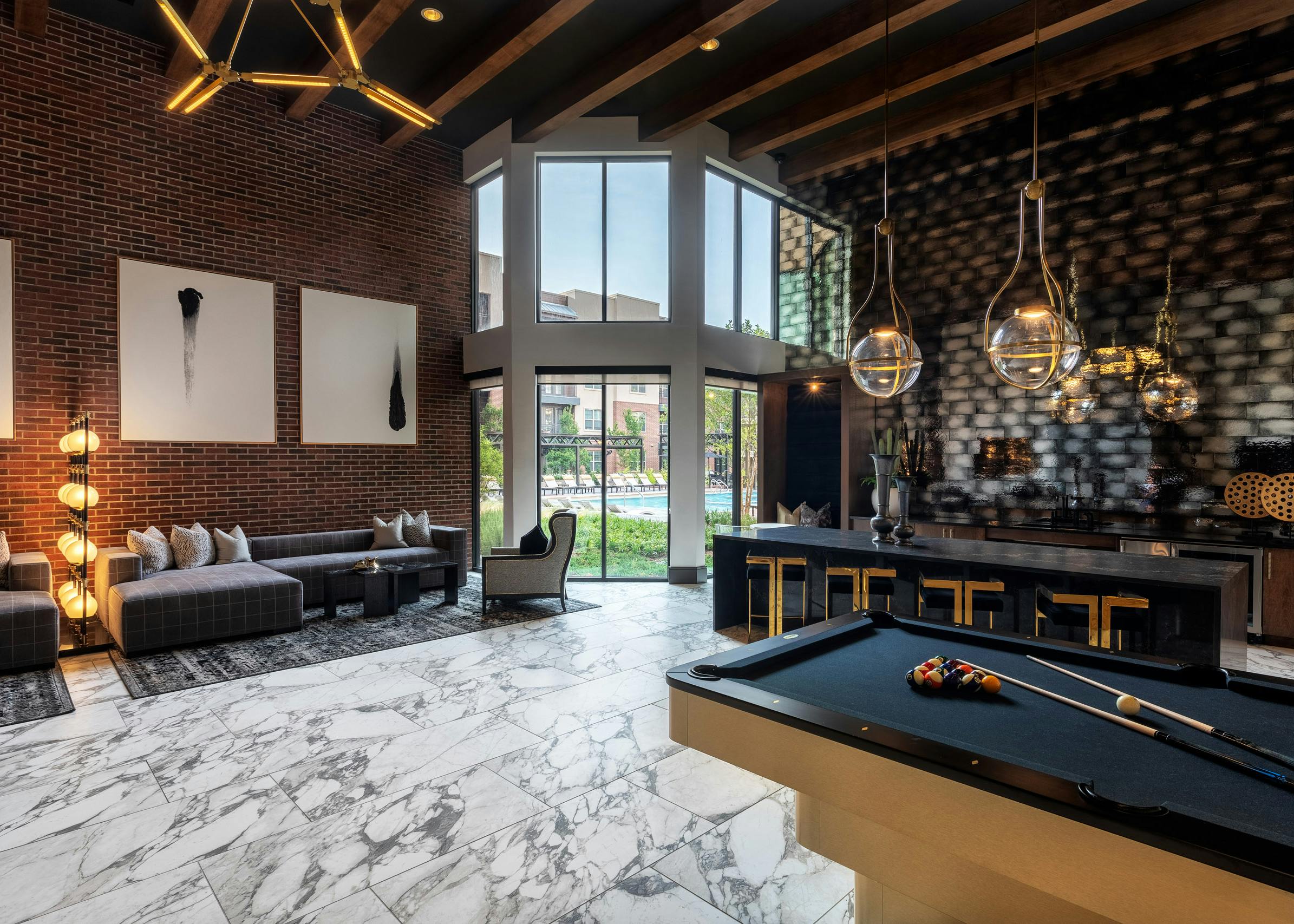 AMLI Grapevine apartment building clubroom with gray tile flooring and catering kitchen and lounge seating and pool table