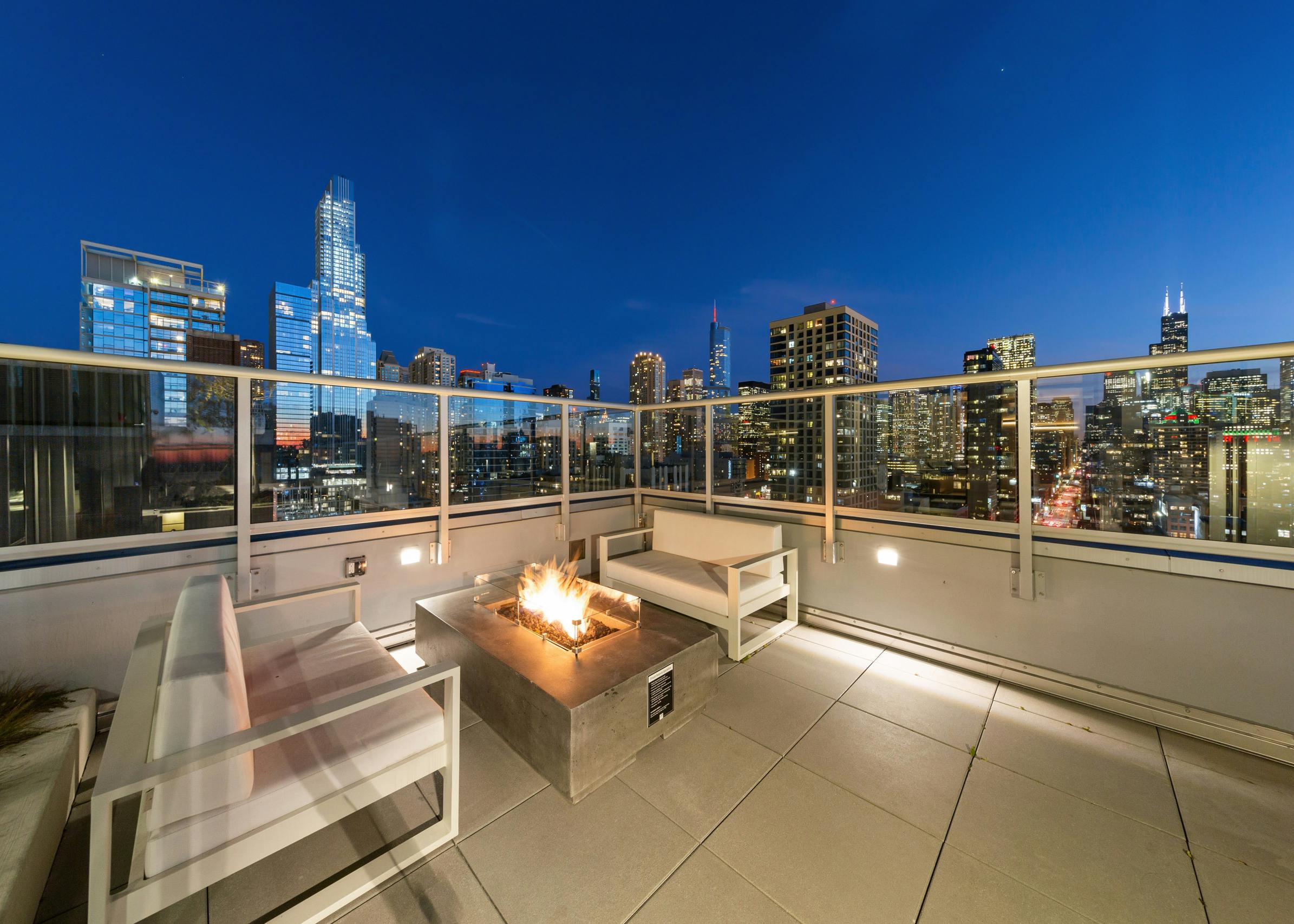 AMLI 808 rooftop grill with stainless steel fixtures and ample seating options surrounded by bright lights on a Chicago night
