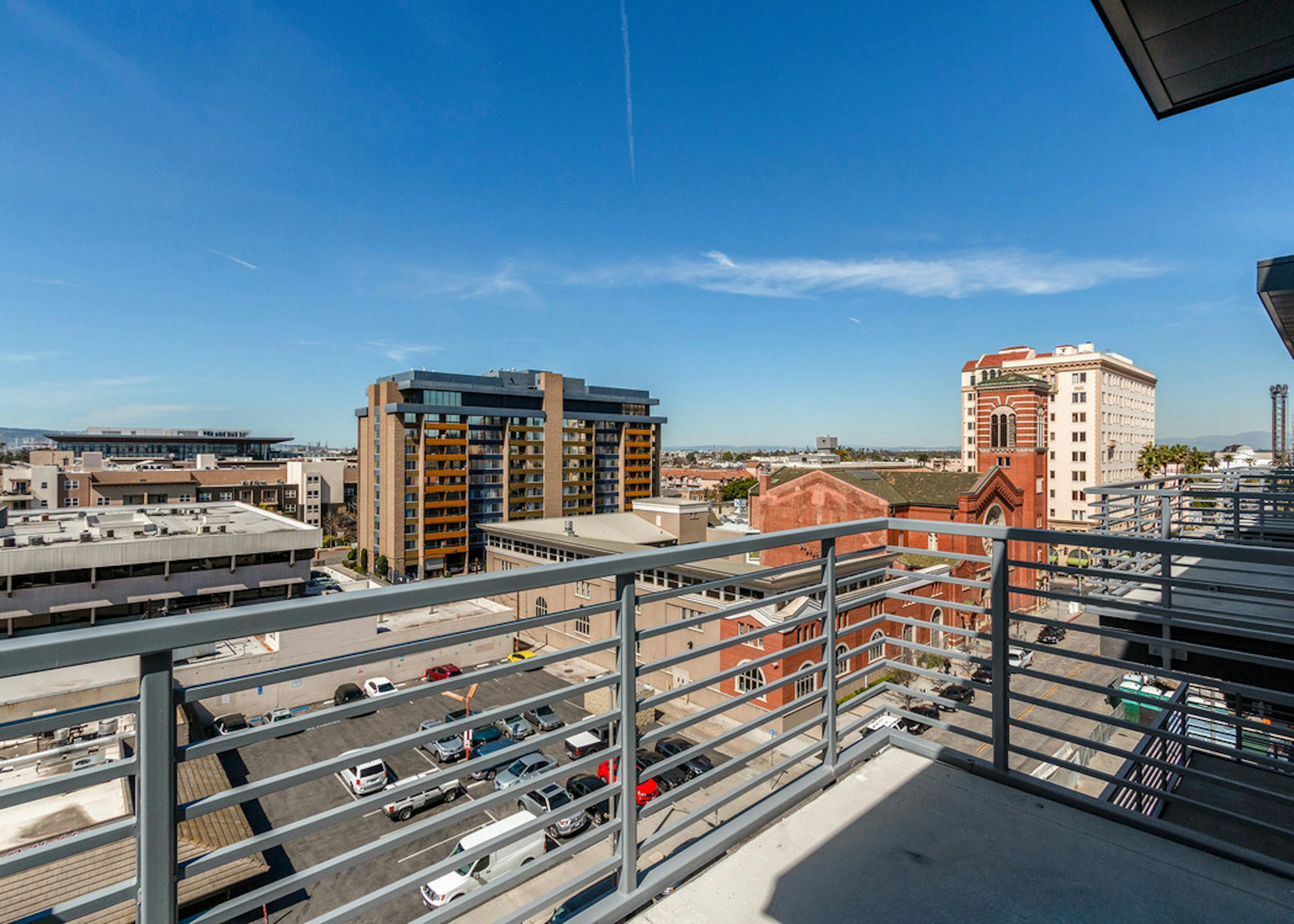 Panoramic daytime view of sunny Downtown Long Beach from private balcony with metal railing at AMLI Park Broadway apartments