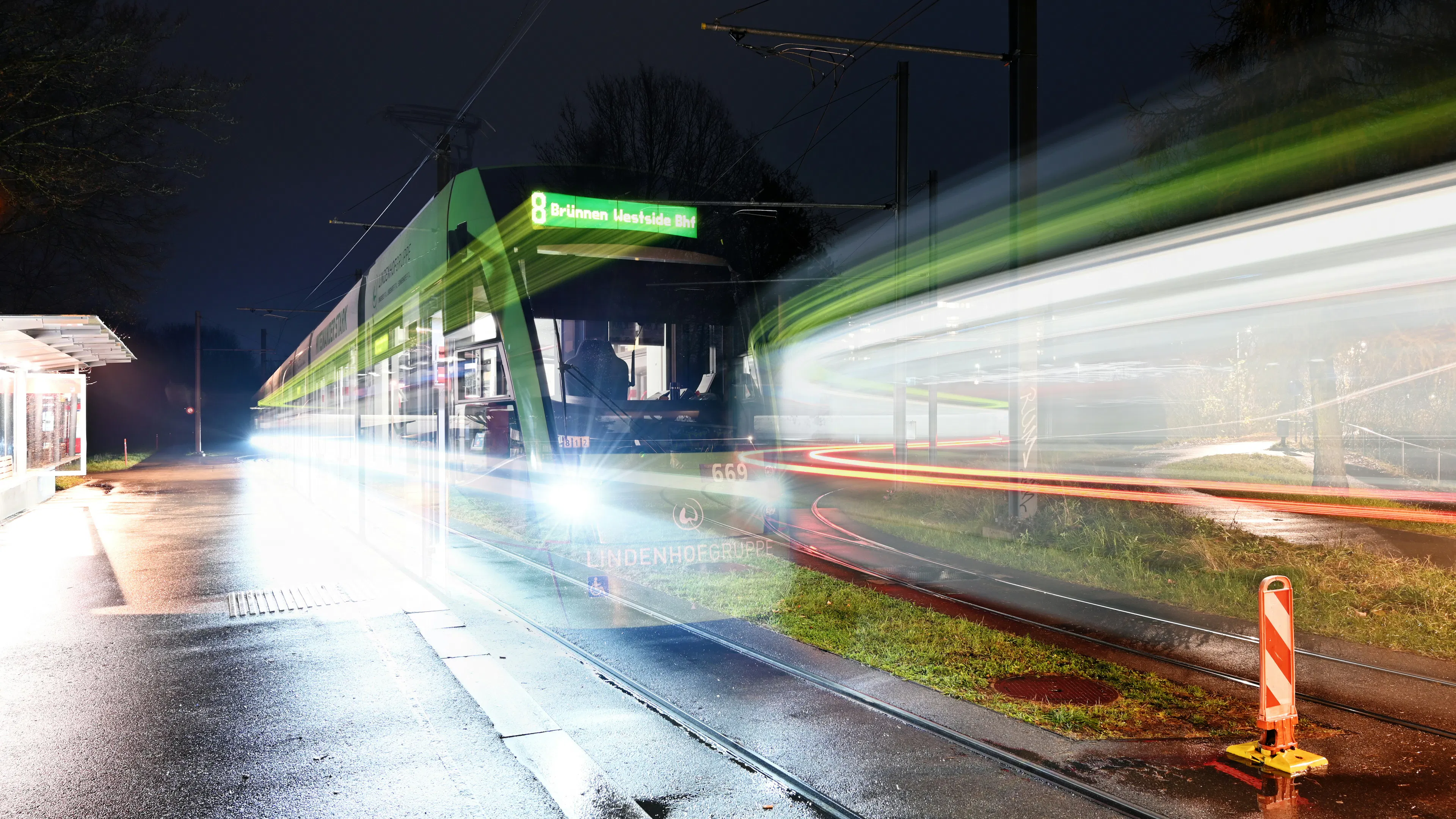 A long exposure shot of a light rail train passing by a platform at night