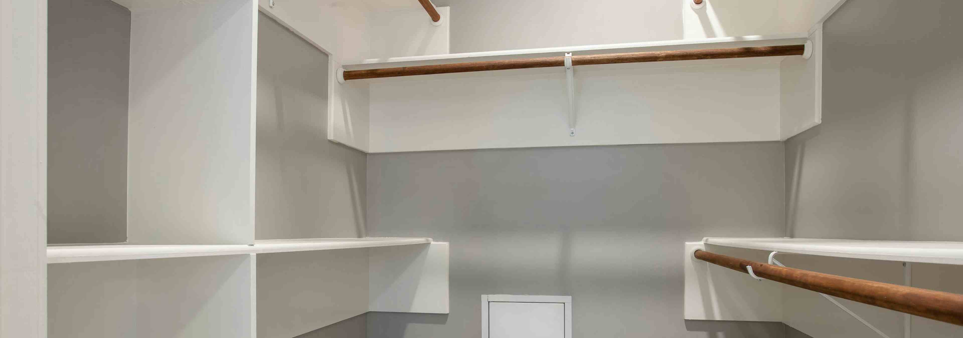 Interior view of walk in closet at AMLI Downtown with built in shelving of varying heights and space to hang clothing