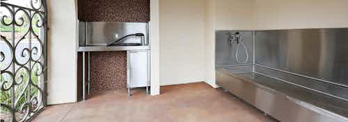 Interior daytime view of paw wash at AMLI Spanish Hills apartment building with stainless tub, grooming counter and dryer