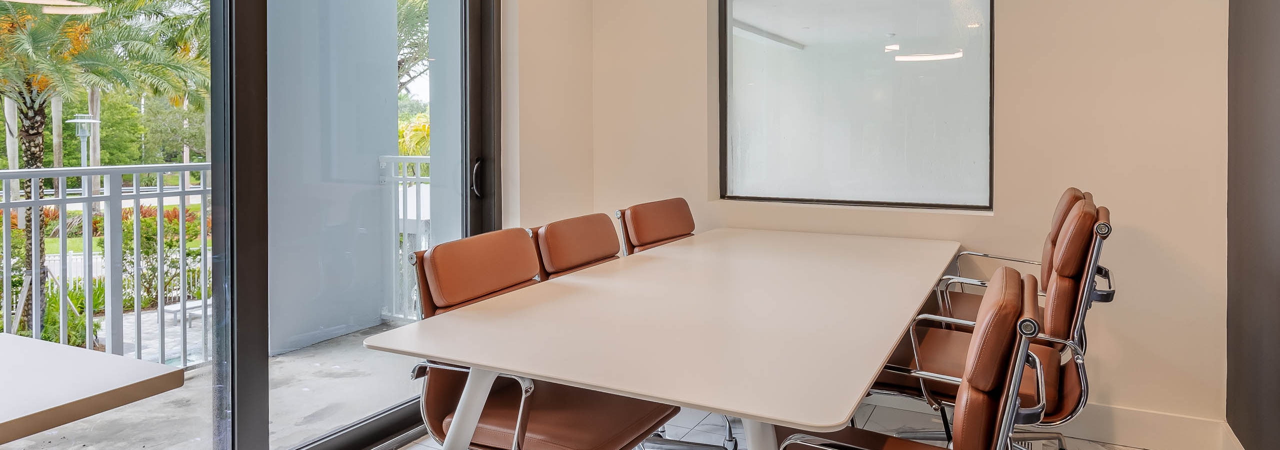 AMLI Park West apartment private office with rectangular conference table and desk chairs and chandelier with patio view