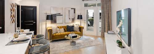 Interior view of AMLI Quadrangle living room with balcony doors and light hardwood with an elegant retro decor style