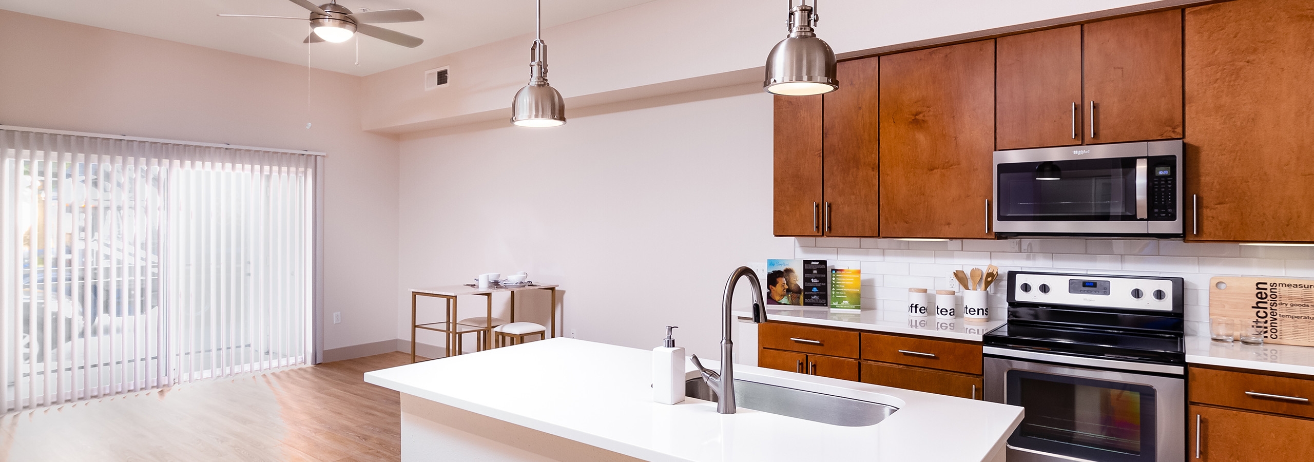 A renovated kitchen and dining room at AMLI Park Avenue apartments with an island and with dining room table and sliding door