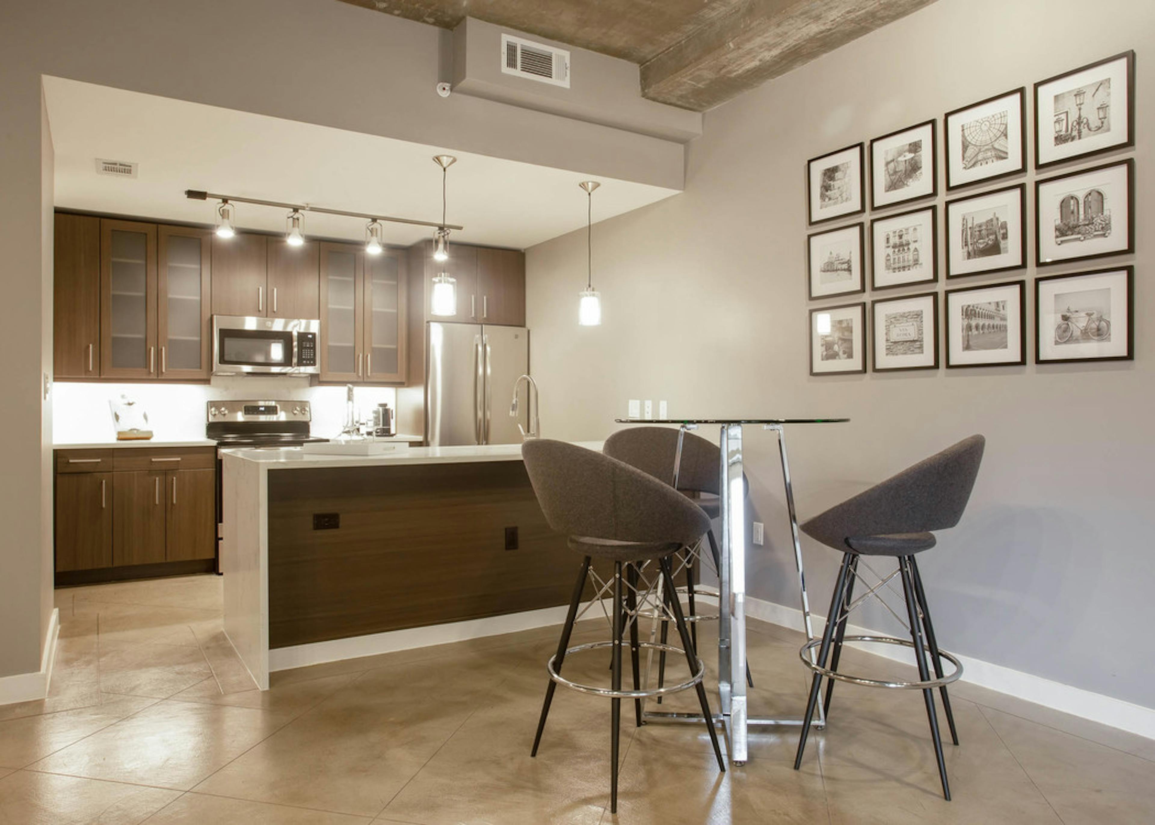 Kitchen at AMLI Downtown with a photo frame collage on the wall with dark cabinets and light countertops