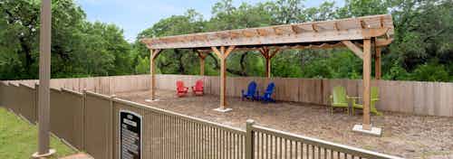AMLI Covered Bridge’s second dog park with a wood chipper floor, wooden shade arch, and colorful lounge seating