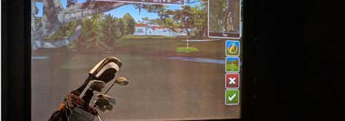 Golf simulator at AMLI River North apartment community showing a virtual golf course for residents to experience