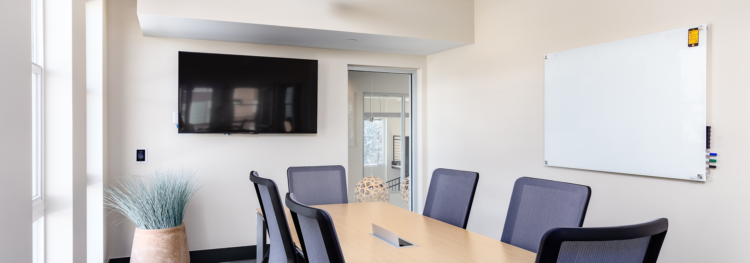 Interior view of private conference room at AMLI Littleton Village apartments with big screen TV and frameless white board