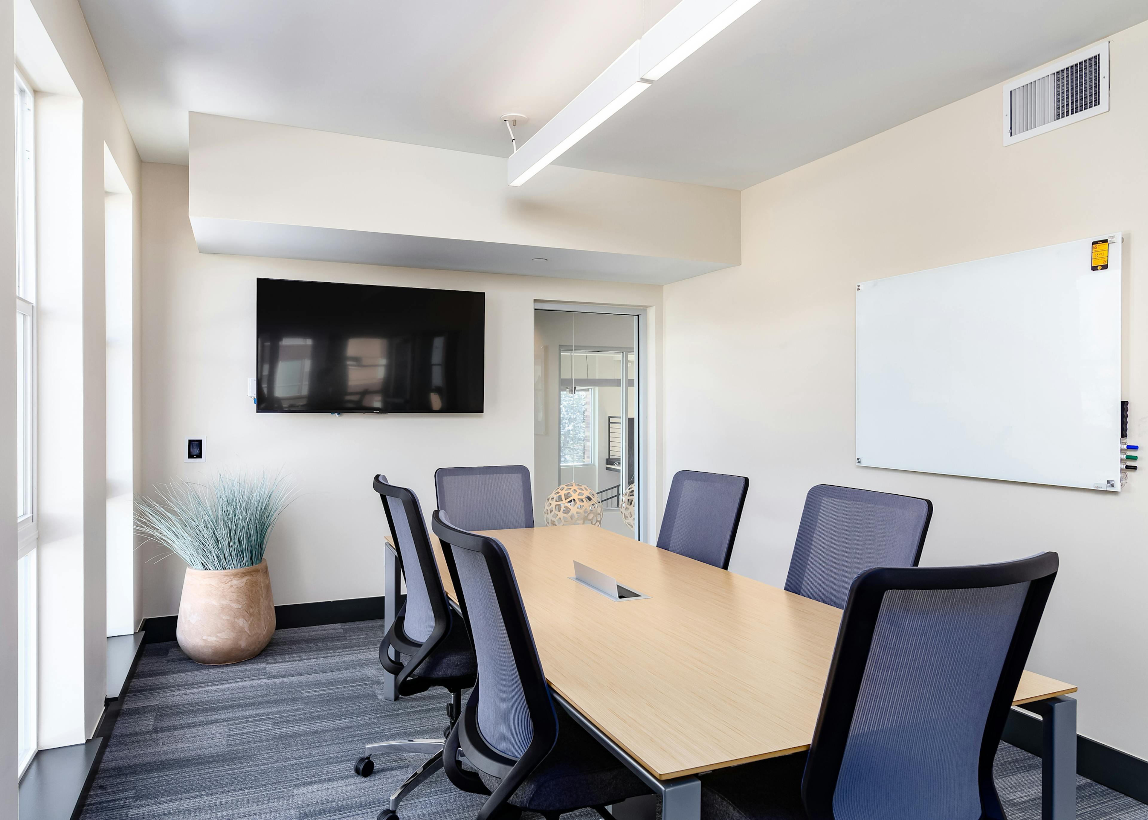 Interior view of private conference room at AMLI Littleton Village apartments with big screen TV and frameless white board